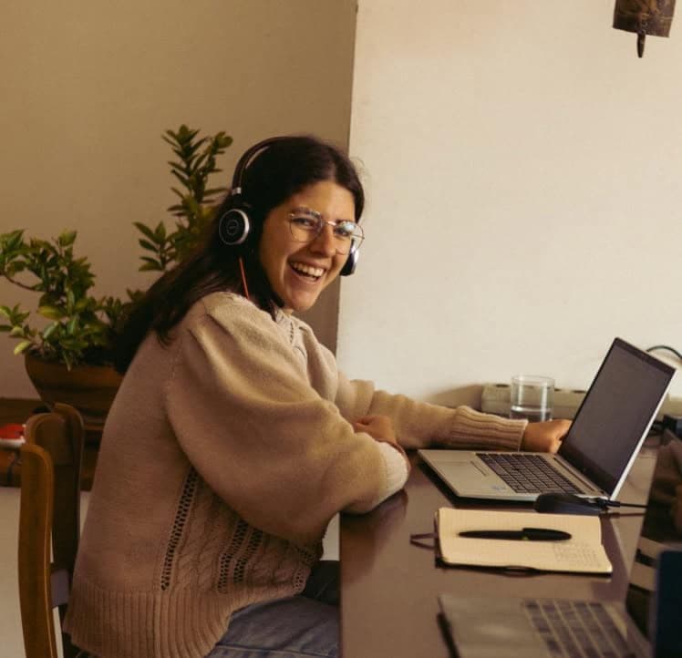 A woman working remotely in a shared coworking space at Masseria Olga coliving in Italy