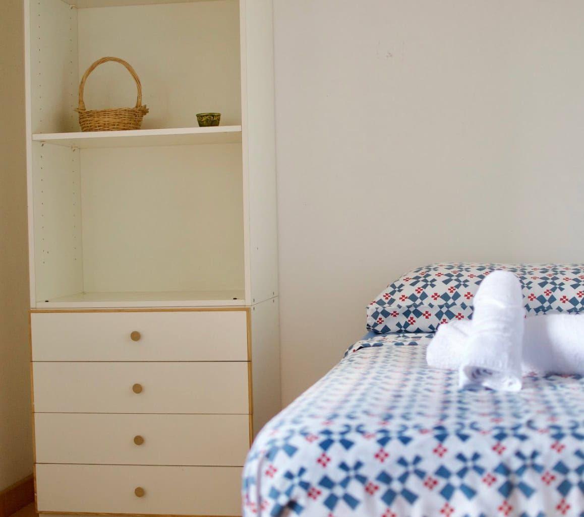 Cozy single room with a patterned bedspread and a built-in storage unit at Masseria Olga coliving in Italy