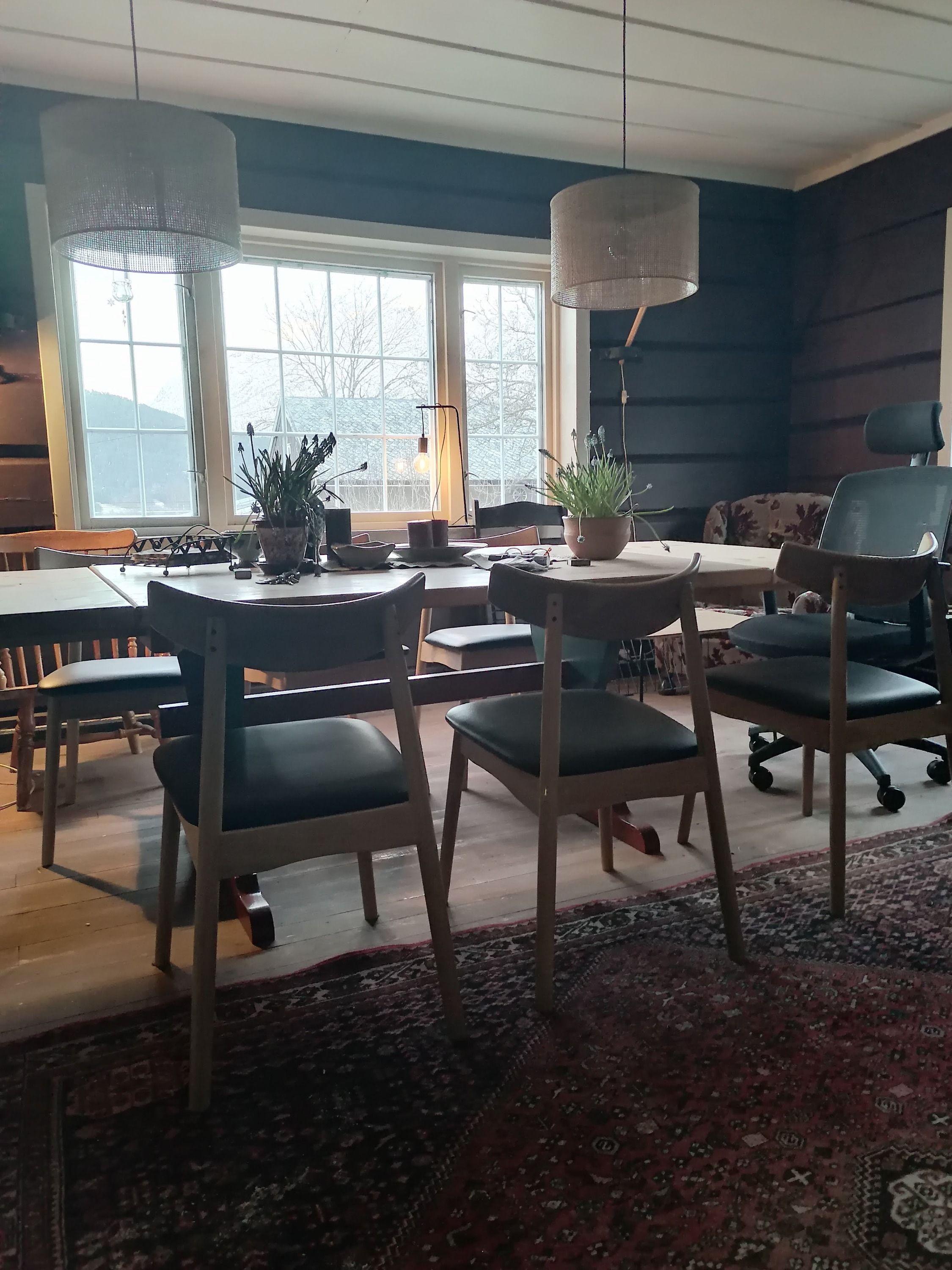 Shared dining area with tables, chairs, pendant lights and windows overlooking the mountains