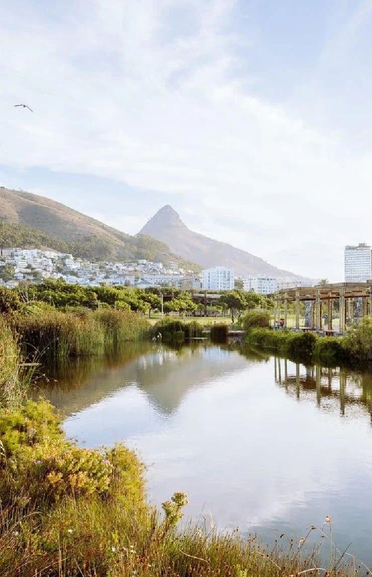 Green Point Park with a lake, lush greenery, and Lion's Head mountain in the background