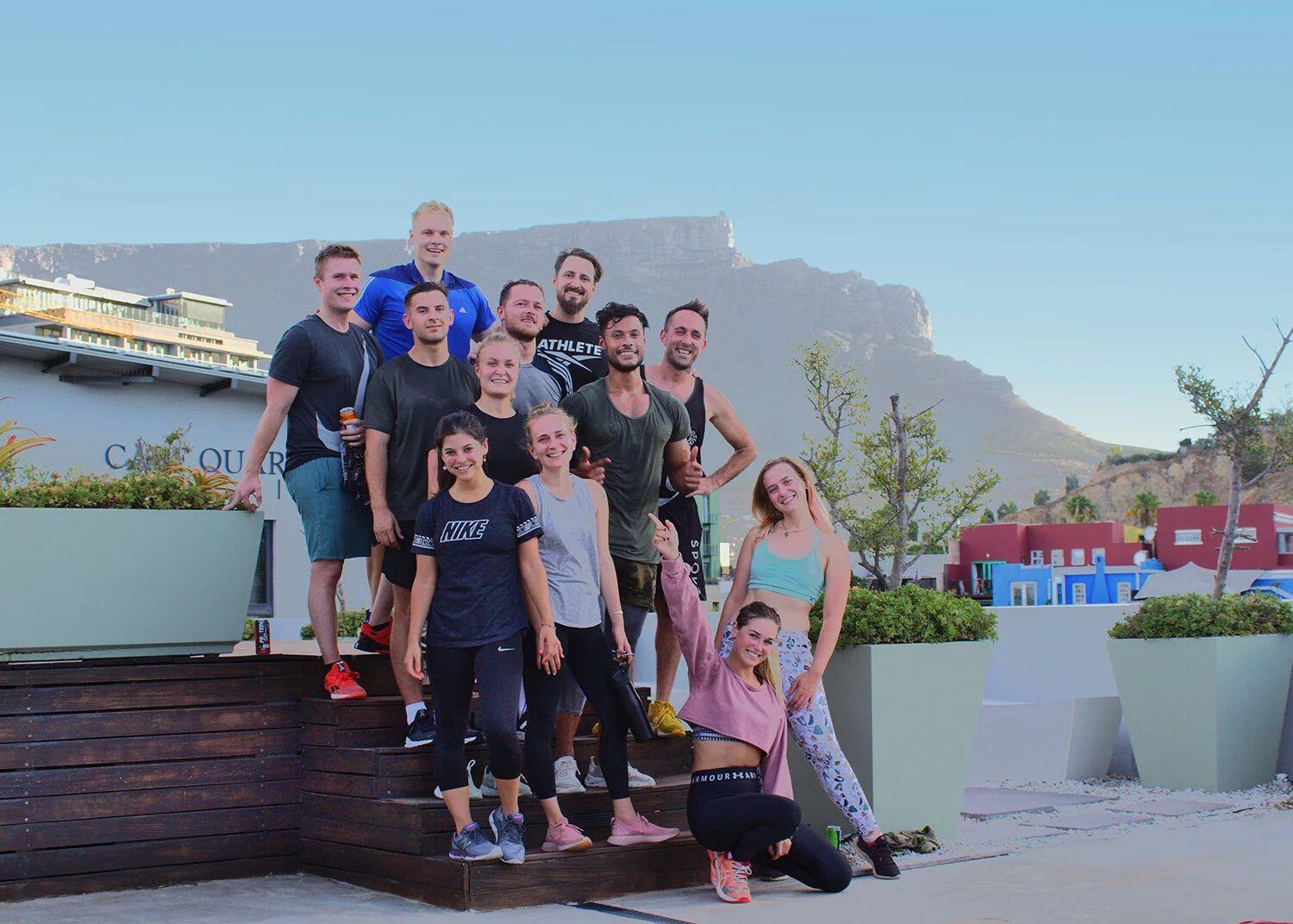 Group of Neighbourgood community members after a run, posing with Table Mountain in the background