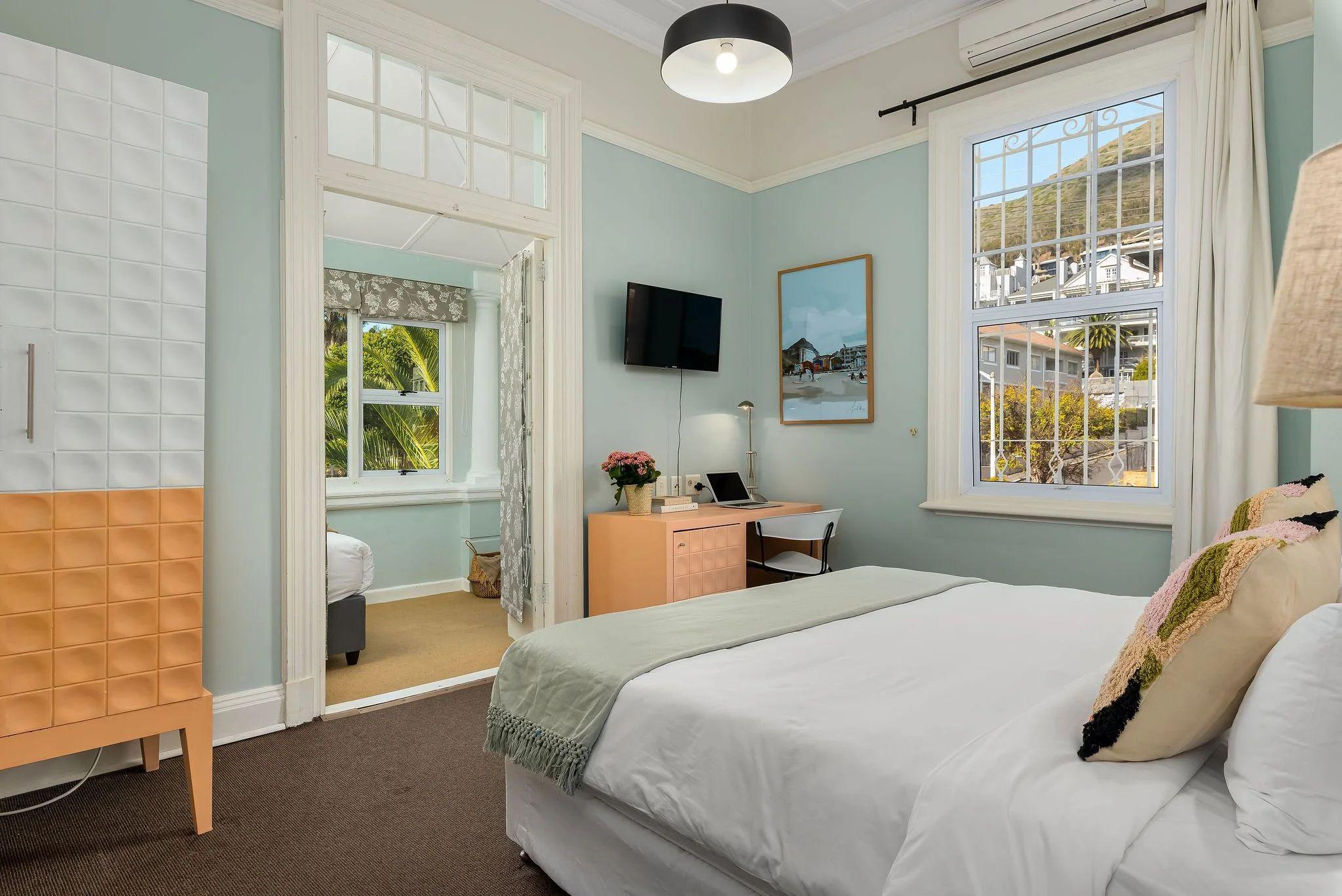 Hill Suites Superior room with king-size bed, high ceilings, large windows with mountain views, and en-suite bathroom