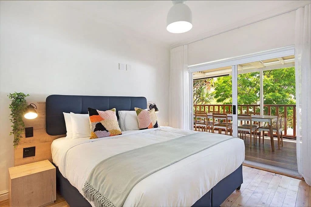 Superior room at Neighbourgood Hill with king-size bed and sliding doors opening to a private balcony with outdoor seating
