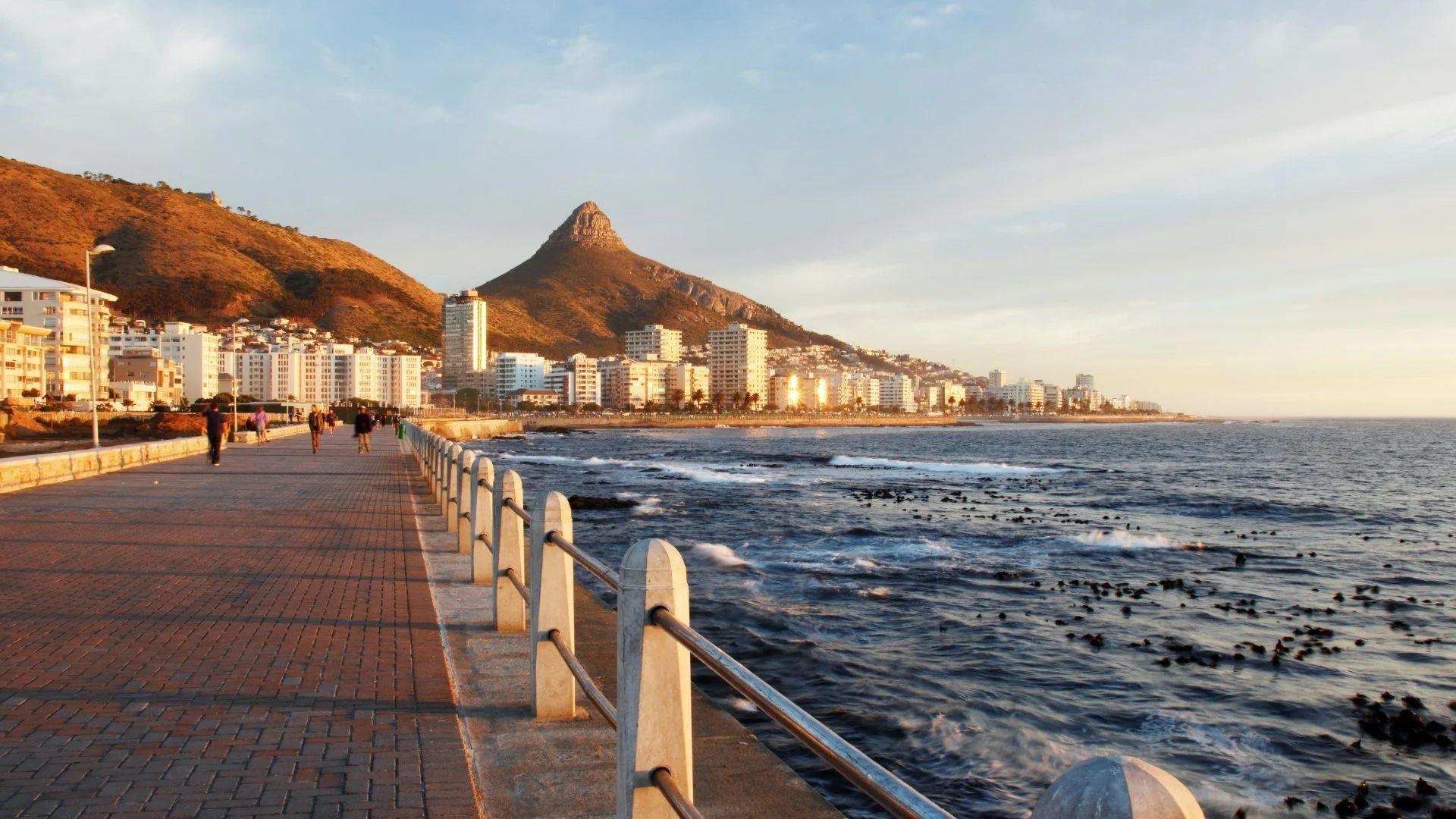 Sea Point Promenade at sunset with Lion's Head mountain in the background and the Atlantic Ocean