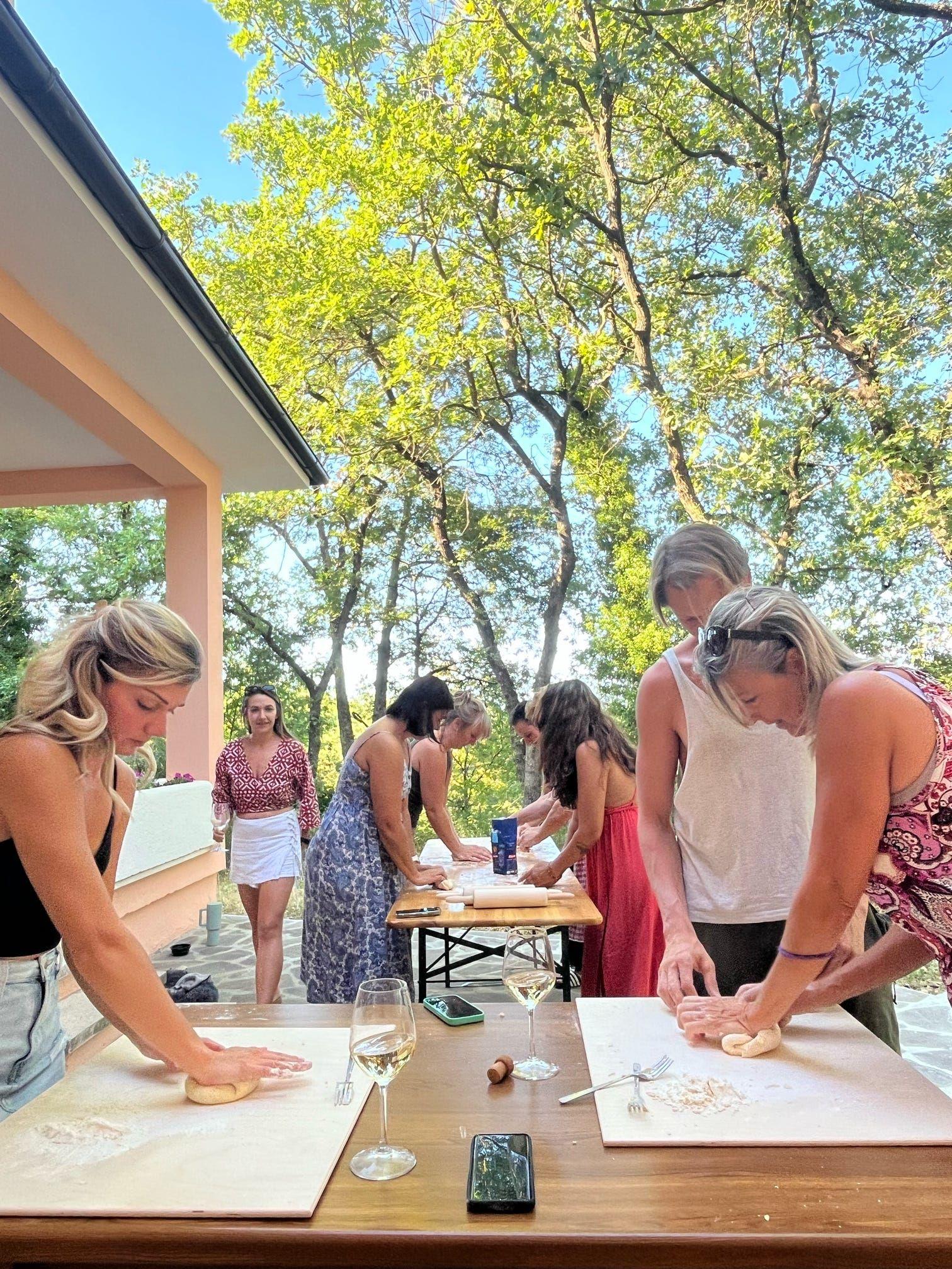 People making fresh pasta in the back veranda garden at a coliving in Italy