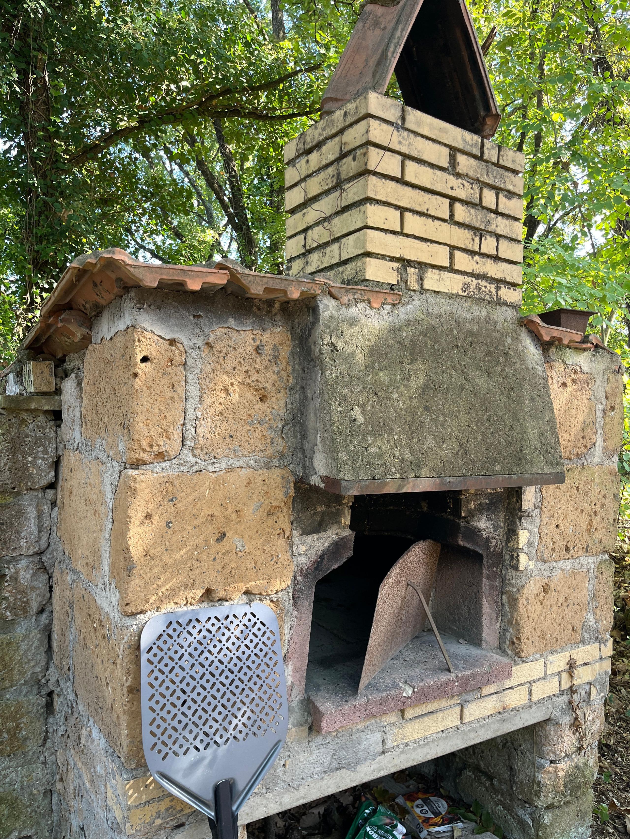Wood-fired pizza oven in the garden of a coliving in Italy near Rome