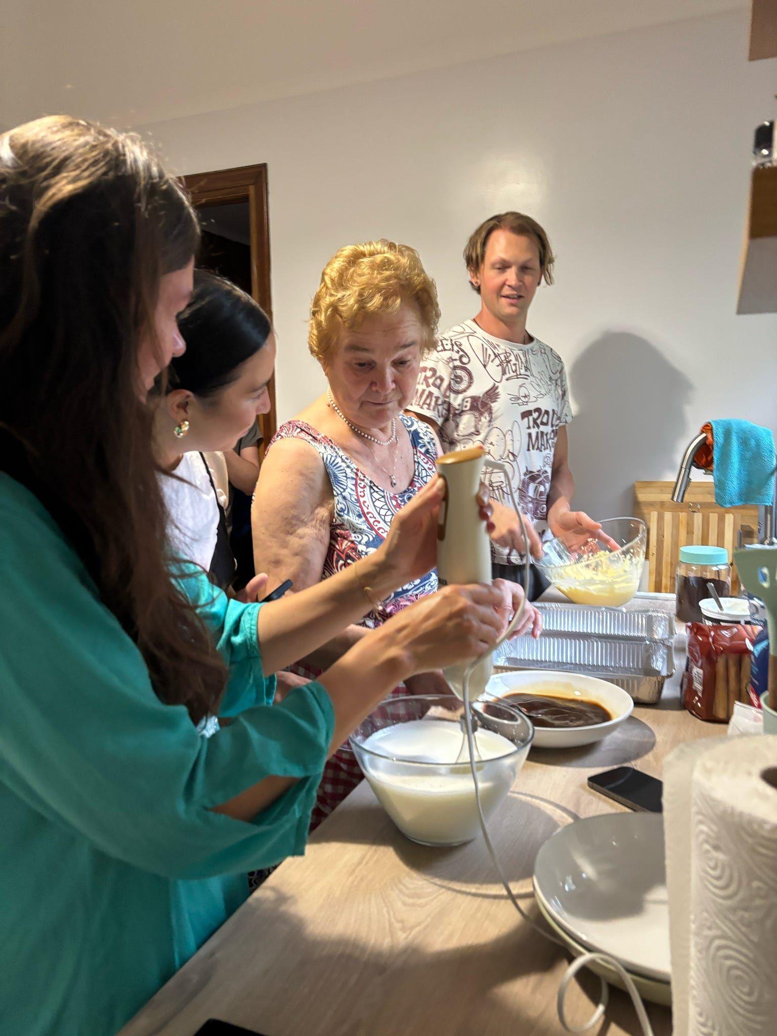 Multiple guests cooking and preparing food together in kitchen at coliving Italy for shared meal