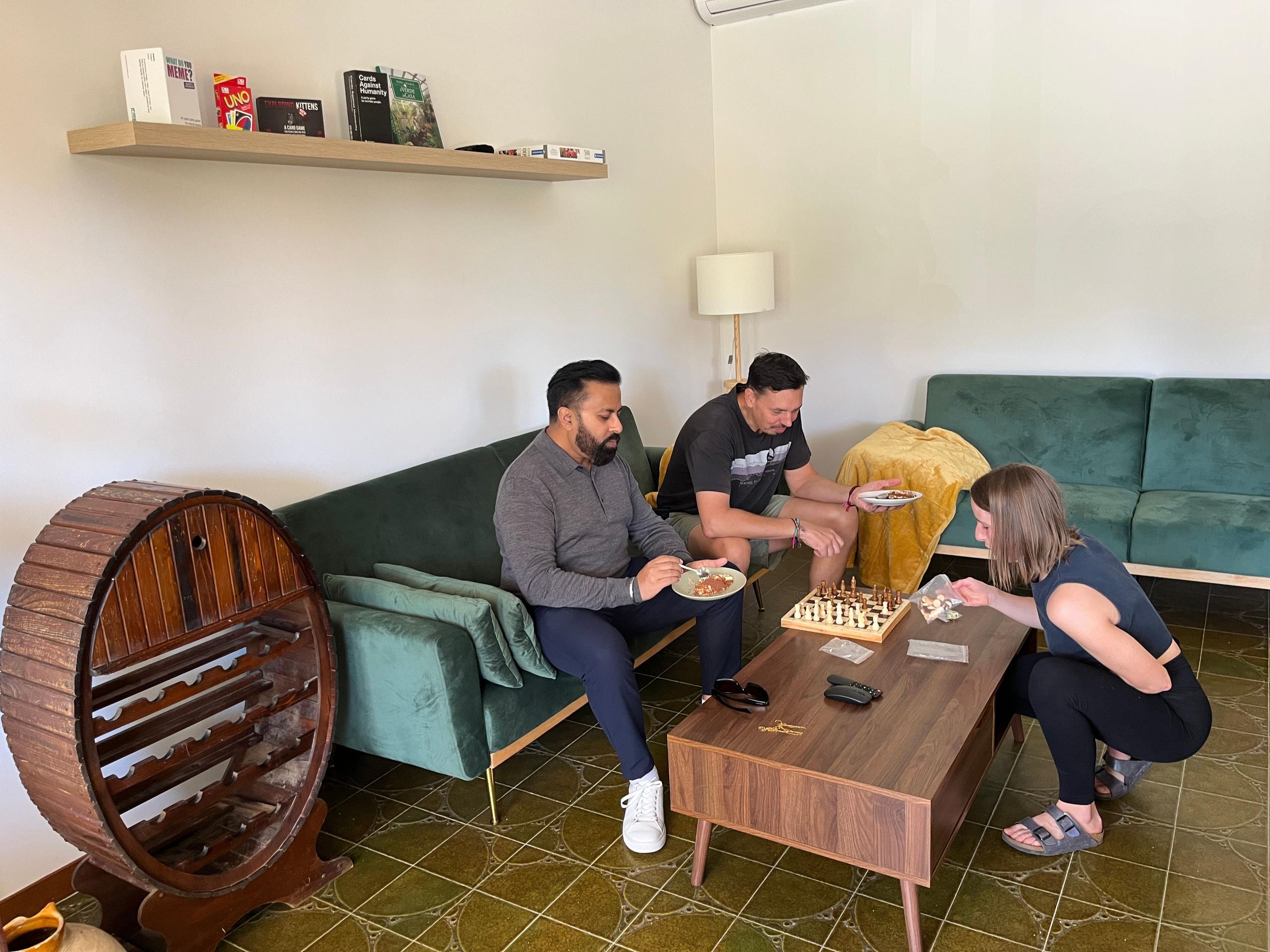 Guests playing chess and socializing in the living room at a coliving in Italy near Rome