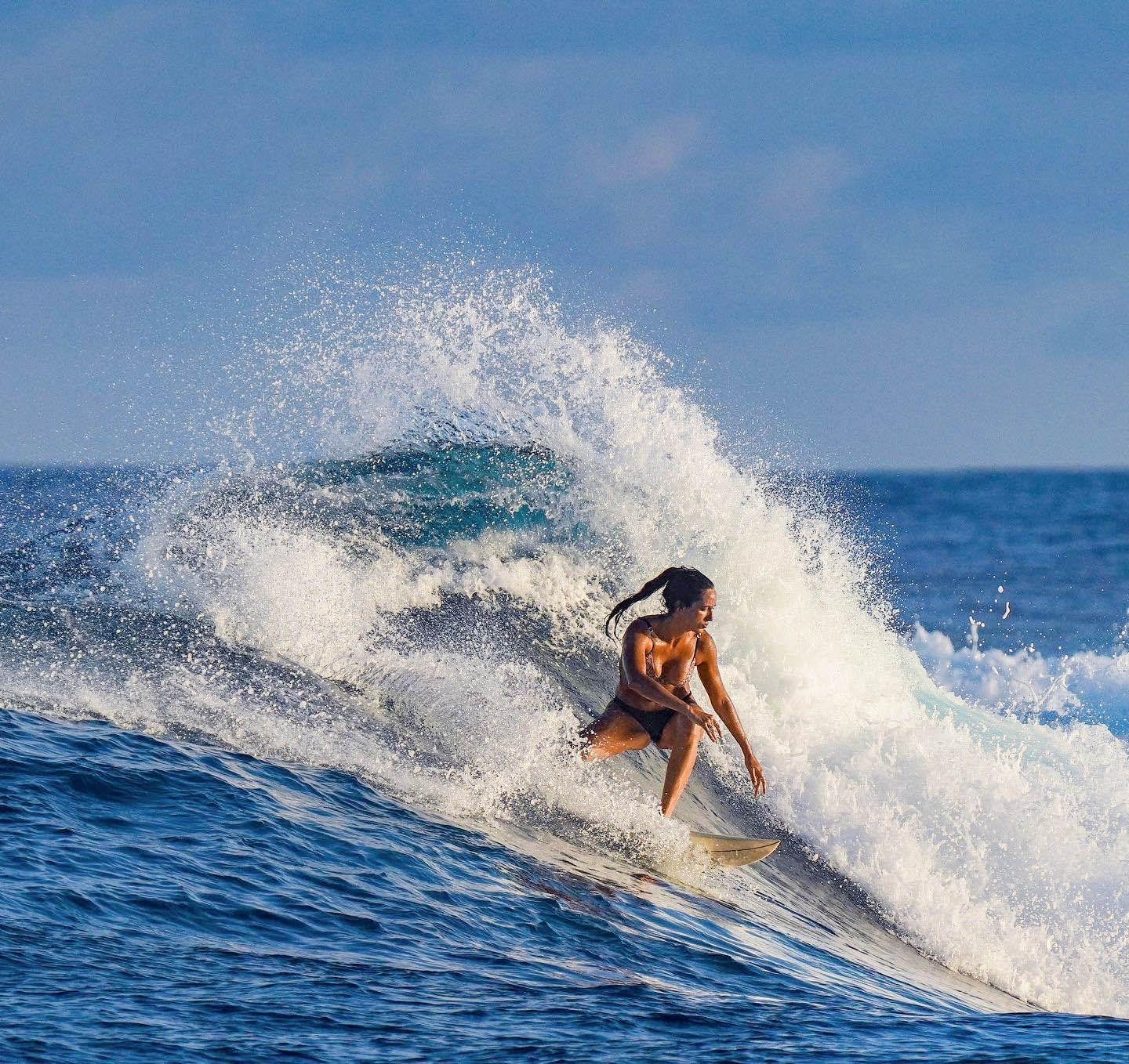 Carmela surfing at Gas Station Surf Point, riding a wave with enthusiasm and skill.