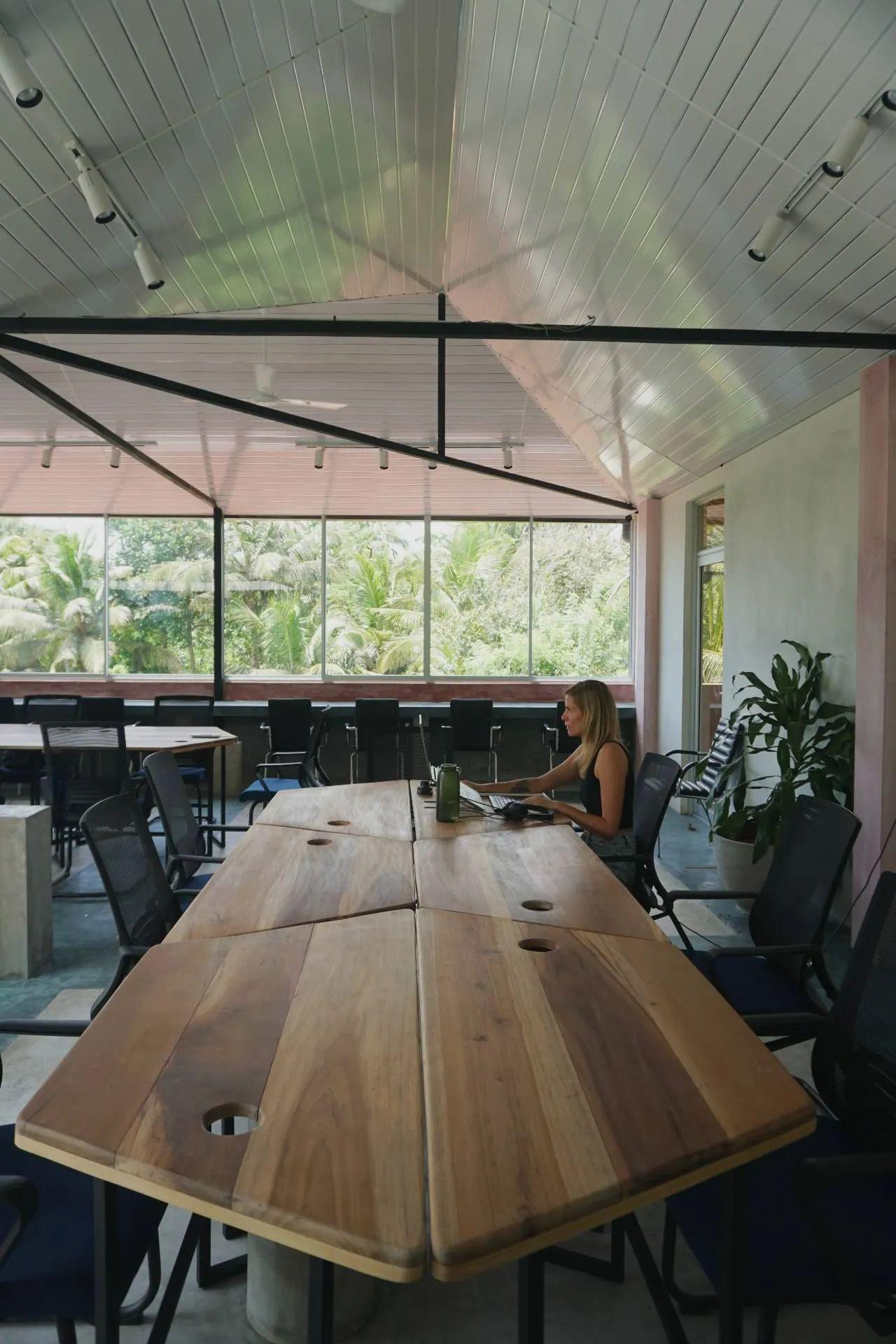 A member working diligently at the coworking space in NETS Cowork and Colive, surrounded by a focused and inspiring environment.
