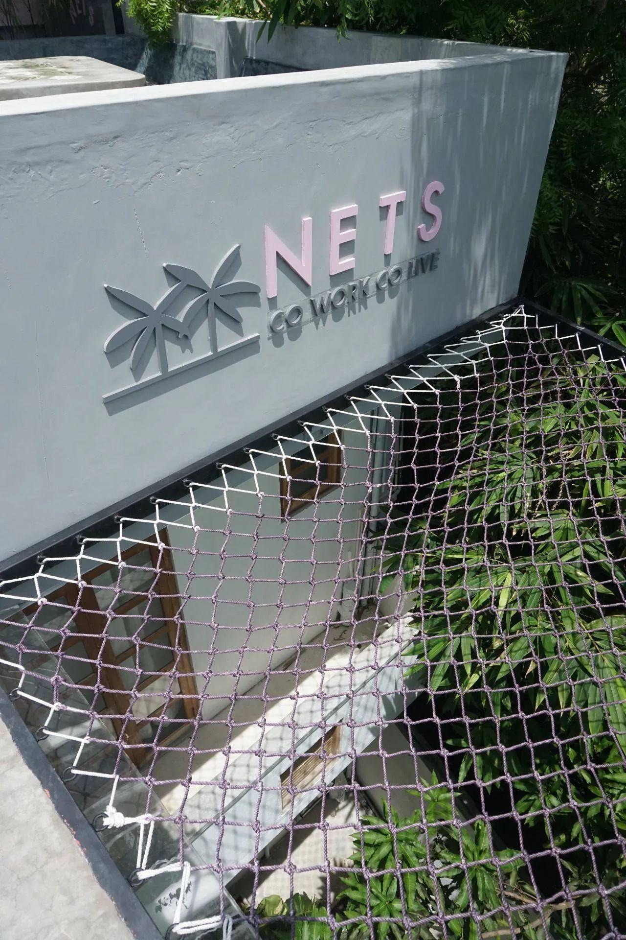 Net canopy area on the rooftop at NETS Cowork and Colive, featuring a relaxing space with shaded seating and panoramic views.