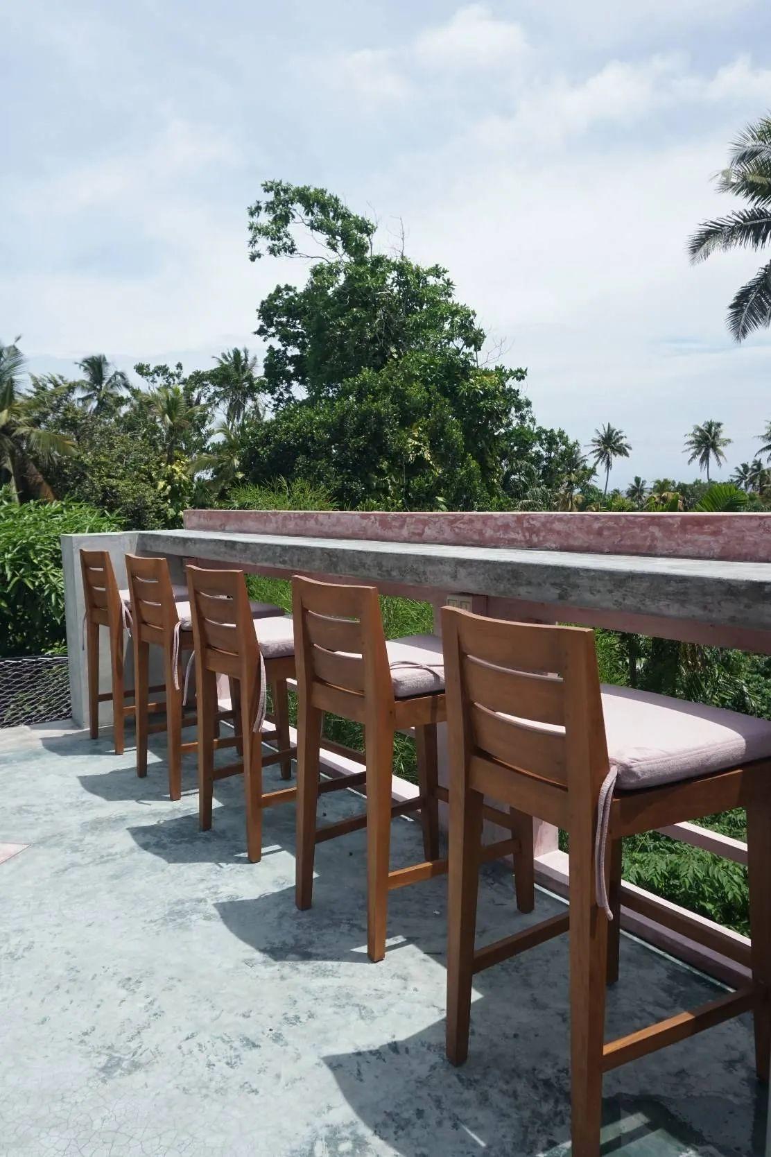 Open area working space at NETS Cowork and Colive with views of the beach and lush greenery.