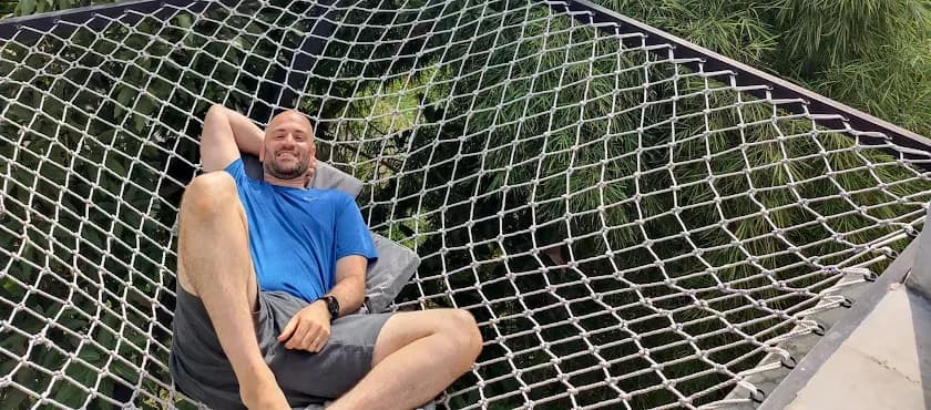 Guest enjoying the net canopy at NETS Cowork and Colive, highlighting a unique and playful relaxation spot.