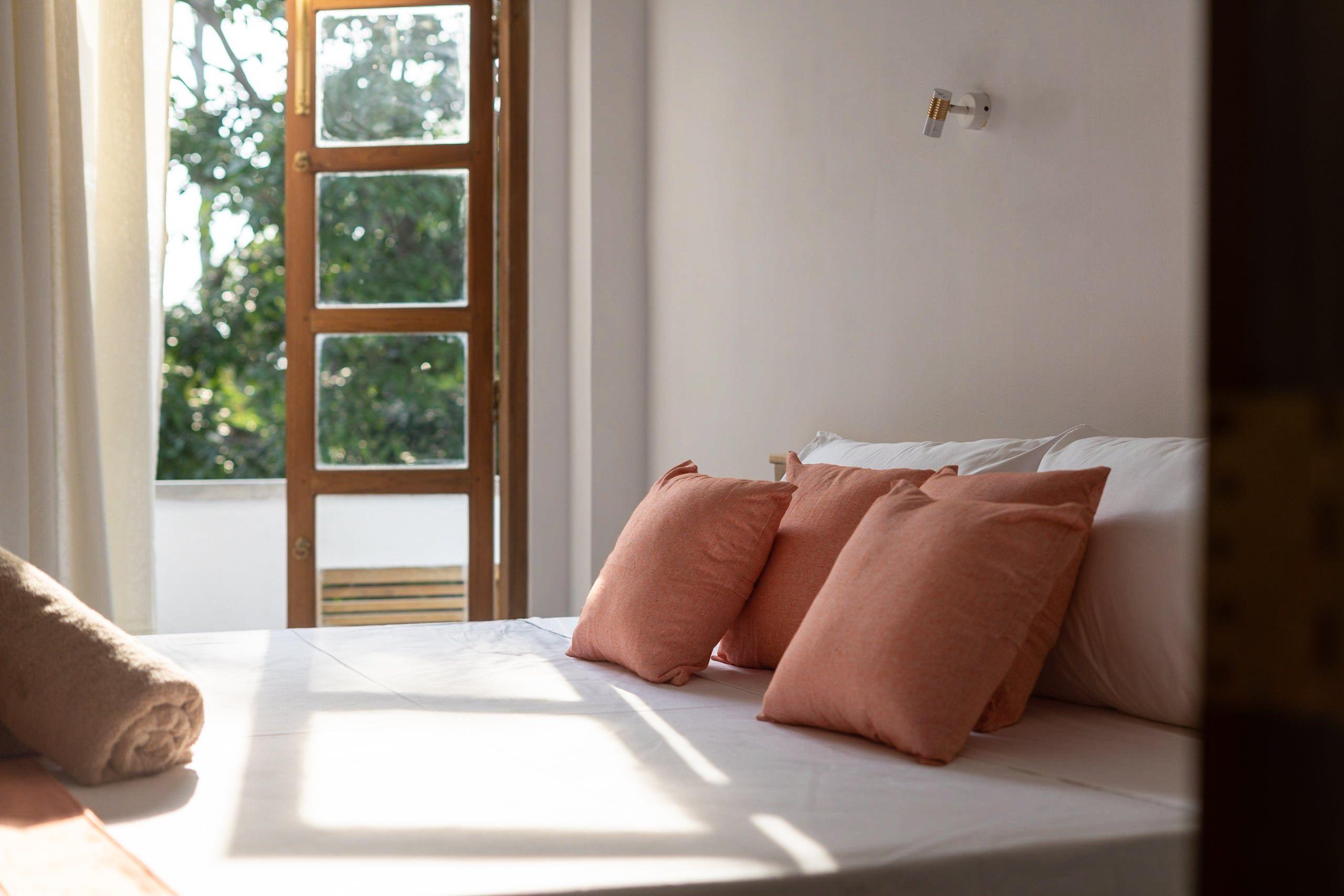 View of the Jungle Suite, showcasing the bed and the balcony area at NETS Cowork and Colive.