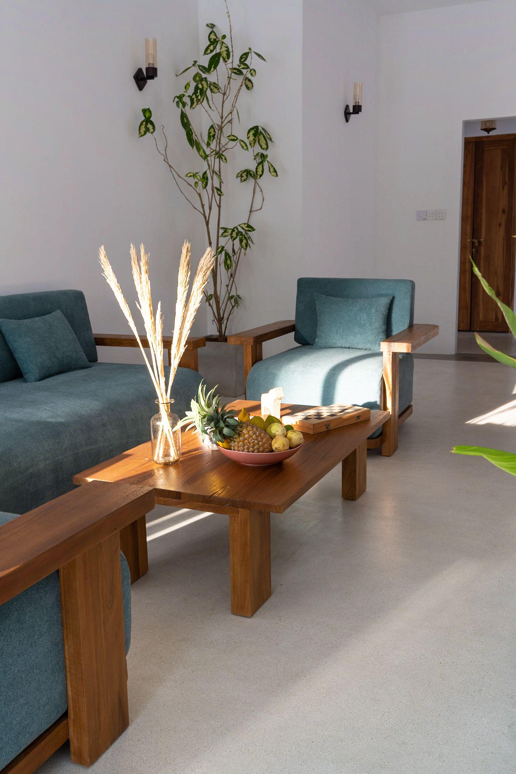 Living area couch with elegant table decorations, bathed in natural sunlight streaming through the windows at NETS Cowork and Colive.