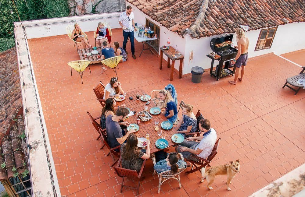 Aerial view of a community BBQ dinner on the rooftop terrace of Nine Coliving, with residents gathered around a large table.