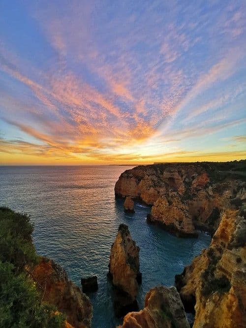 Dramatic golden cliffs and ocean at sunset near Lagos, Algarve, Portugal