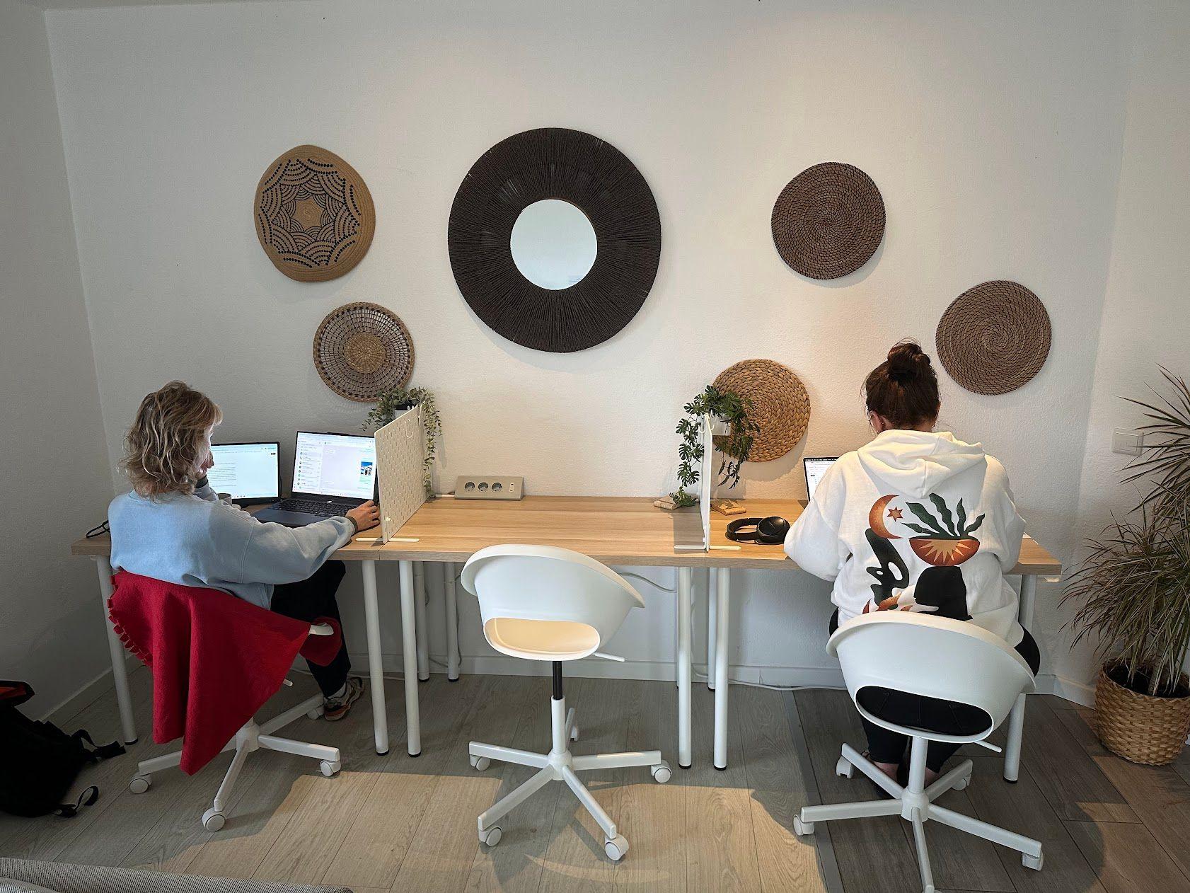 Two people working on laptops at the coworking desks at the Sea View Hub