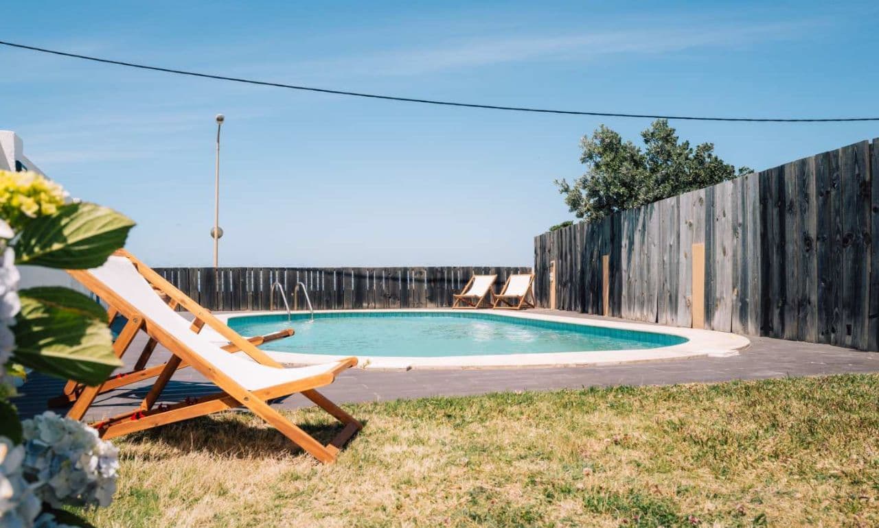 Outdoor pool with sun loungers and garden at the Sea View Hub coliving, Ericeira