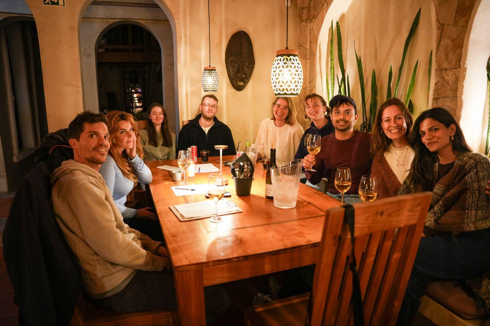 Coliving community group gathered around a table for a dinner in Ericeira