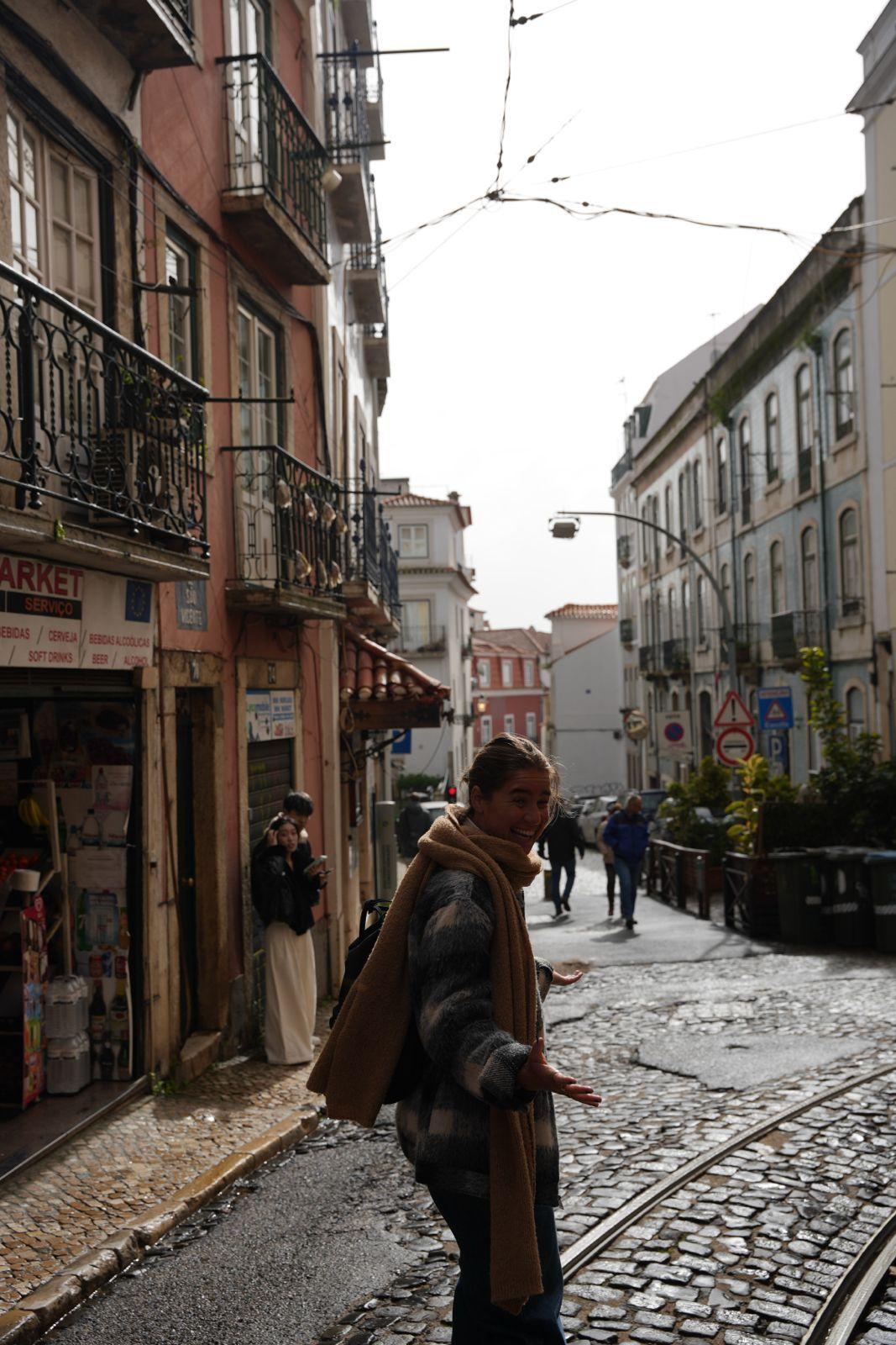 Person walking on a cobblestone street in Lisbon, a popular day trip destination from Ericeira