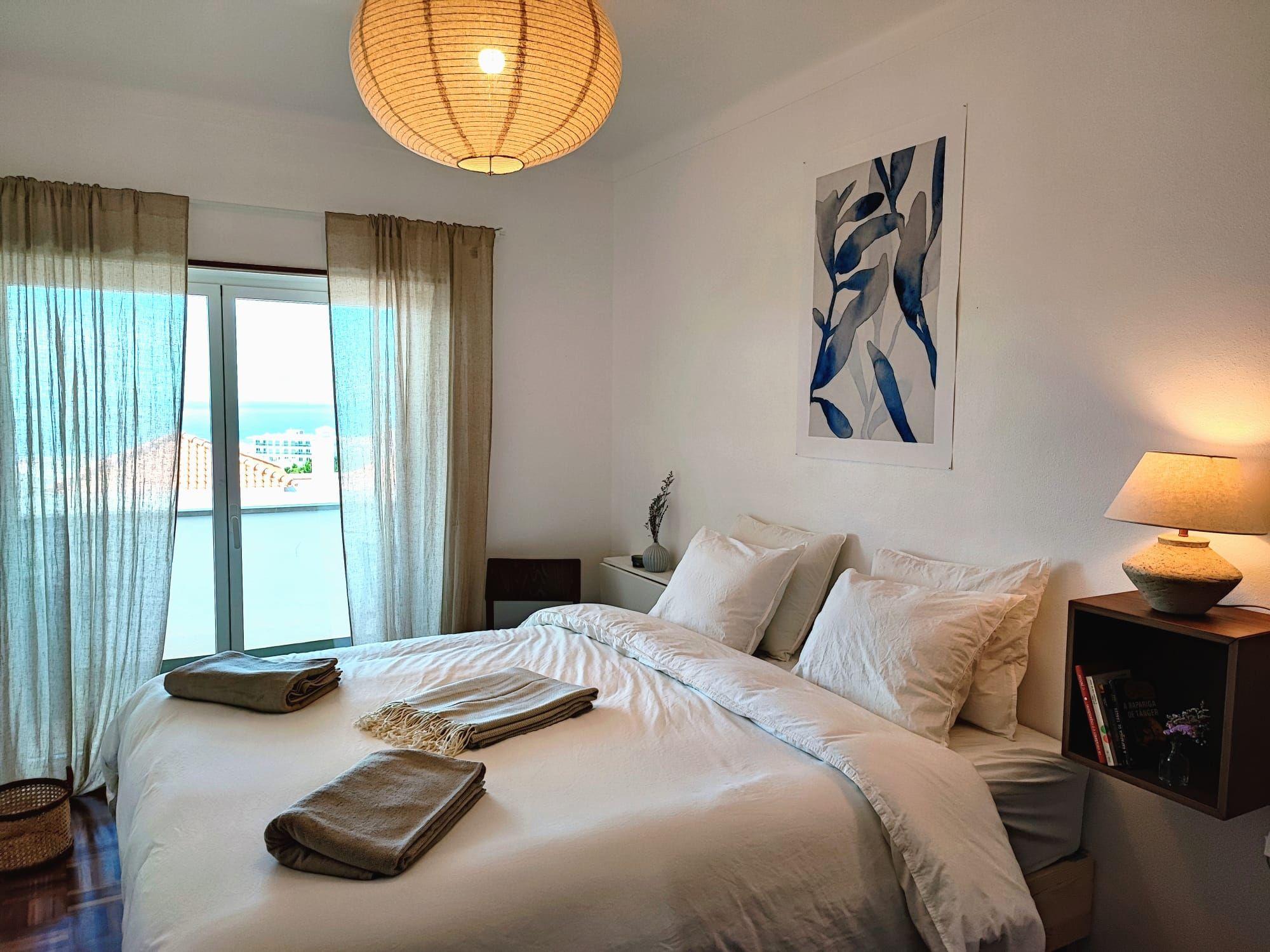 Private bedroom with double bed and ocean view window at Laura's Home coliving