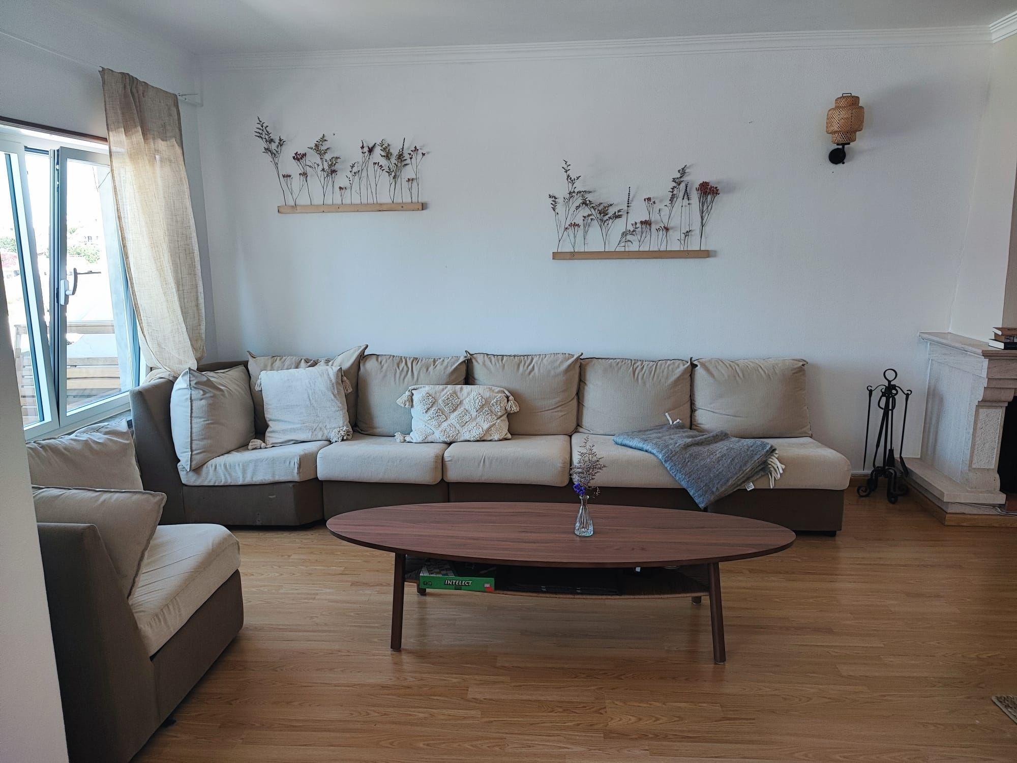 Bright living room with large sofa, coffee table and fireplace at Laura's Home coliving