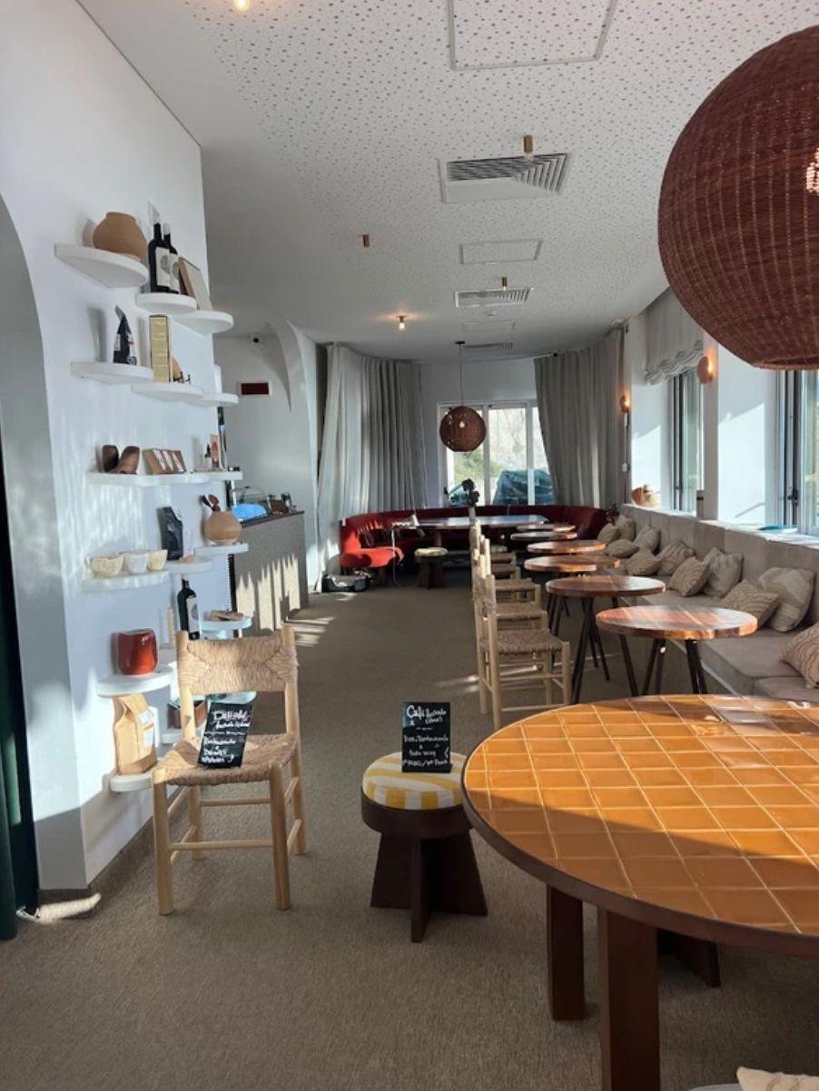 Interior of a stylish local café in Ericeira with tiled tables and ocean view