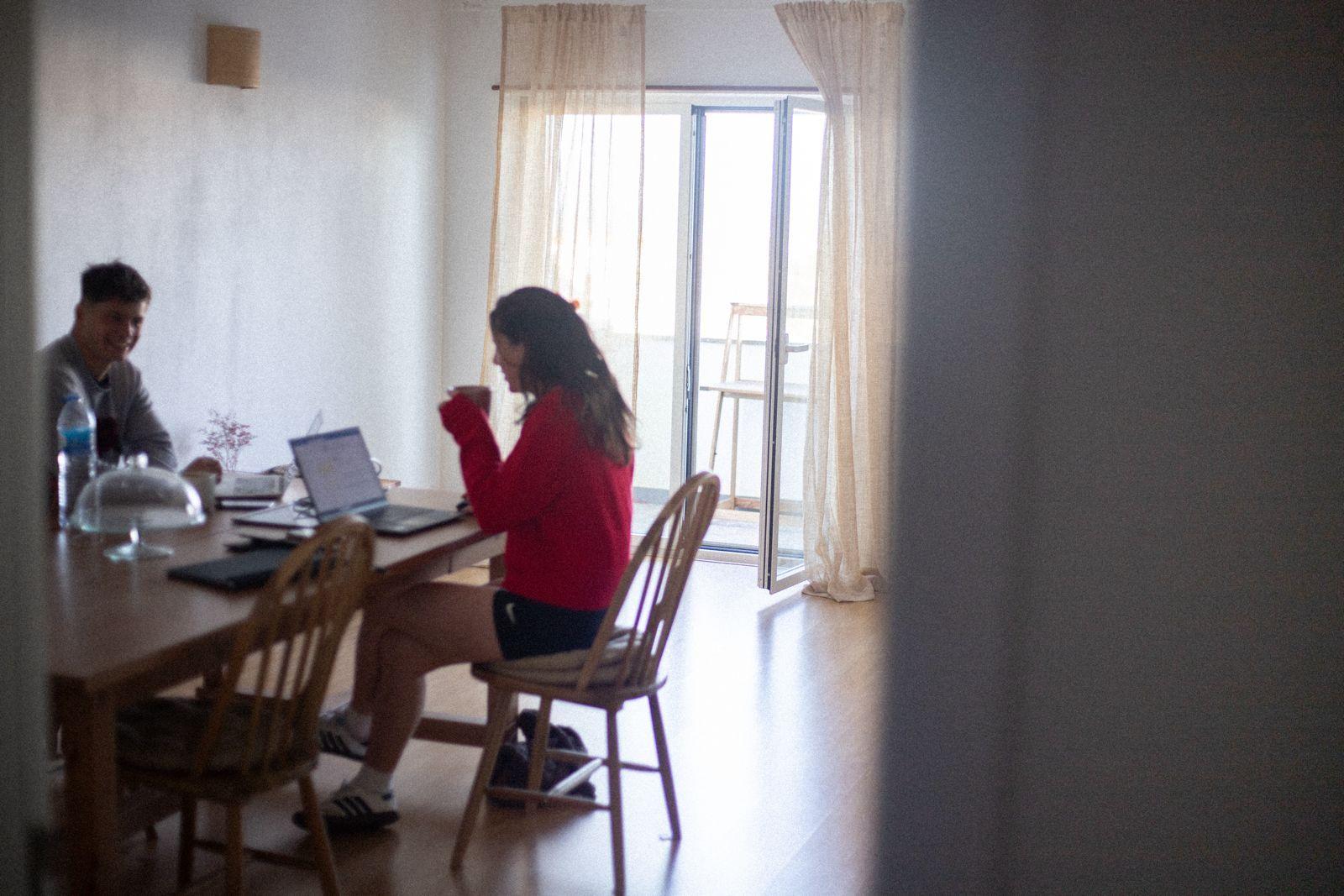 Two people working on laptops at the dining table in Laura's Home bright living room