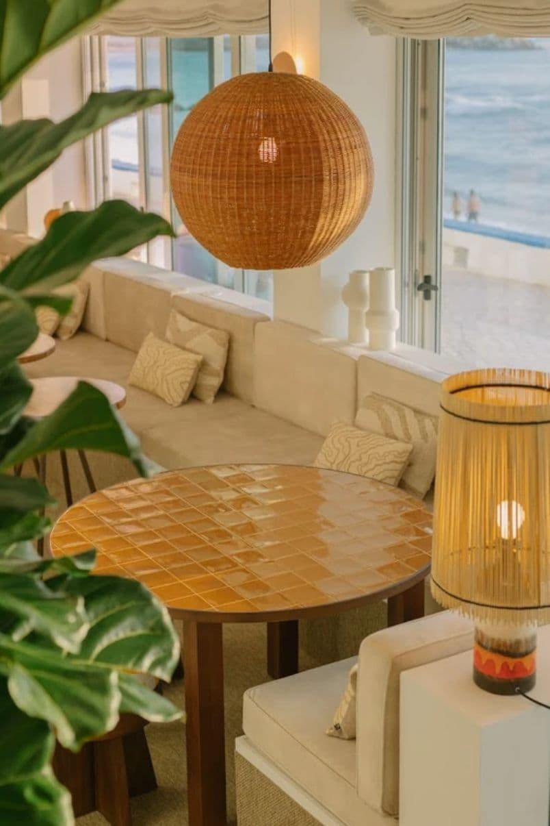 Cozy café seating area with ocean view through large windows in Ericeira