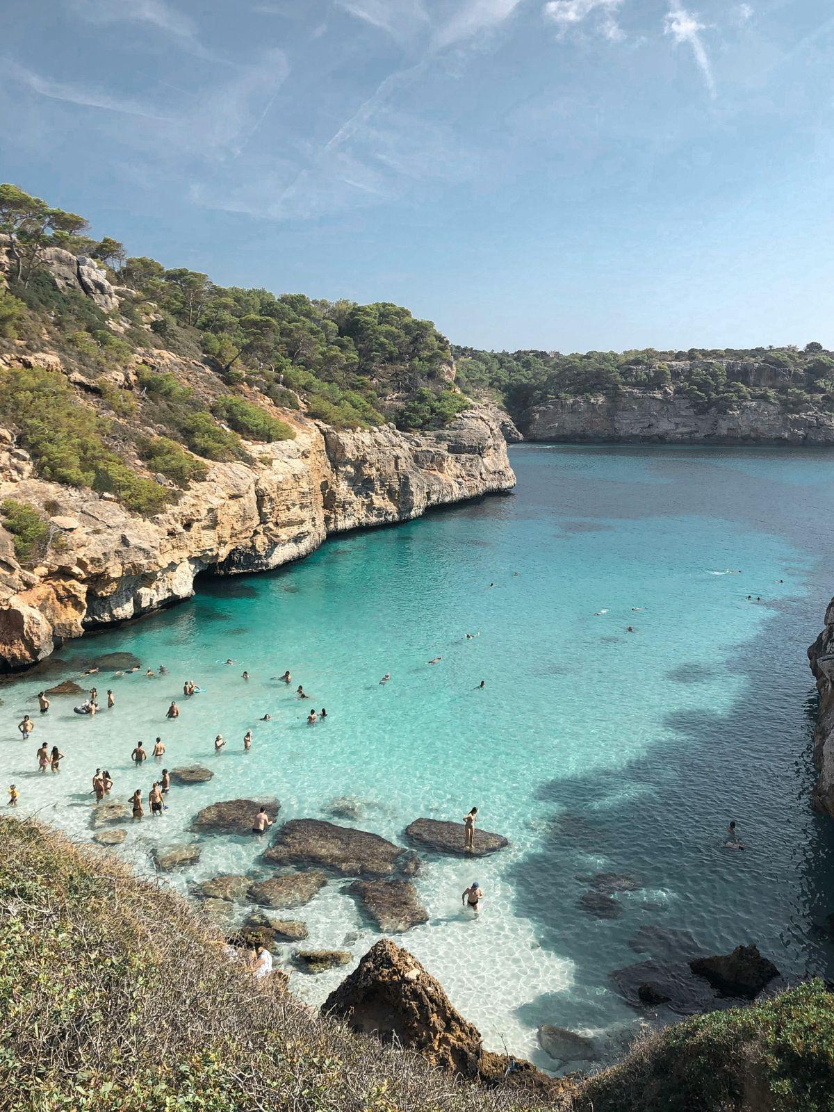 Scenic turquoise cove with swimmers in Mallorca