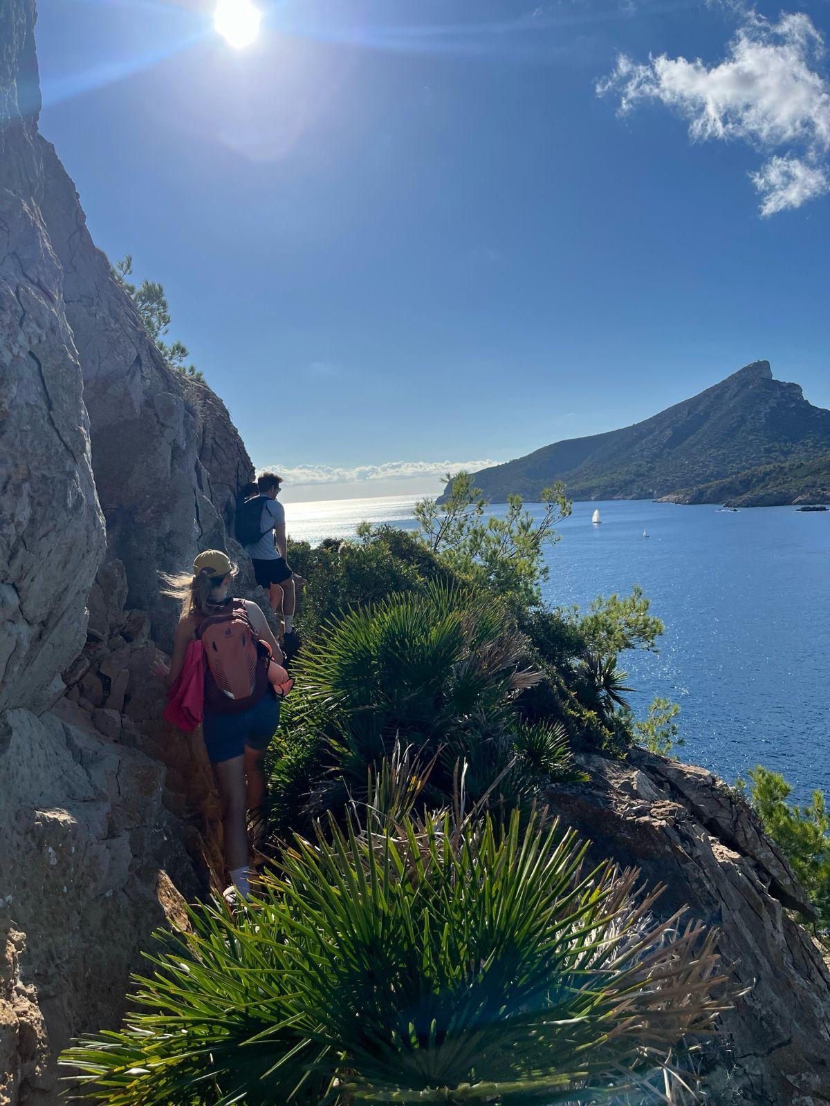 Guests hiking along a coastal trail with sea and mountain views in Mallorca