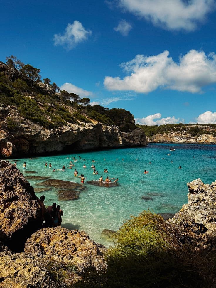 A turquoise cove in Mallorca with people swimming