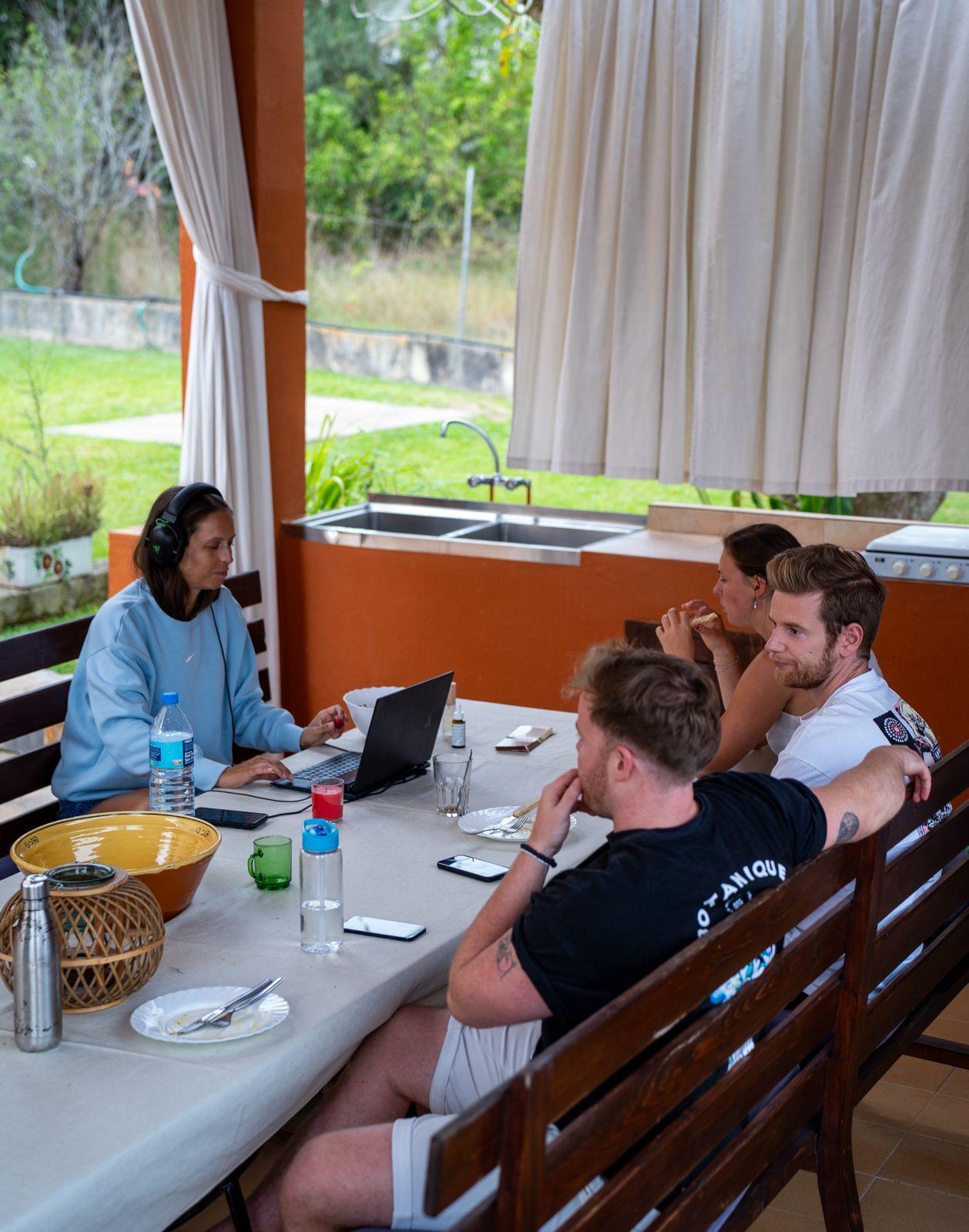 Guests working on laptops from the covered patio area