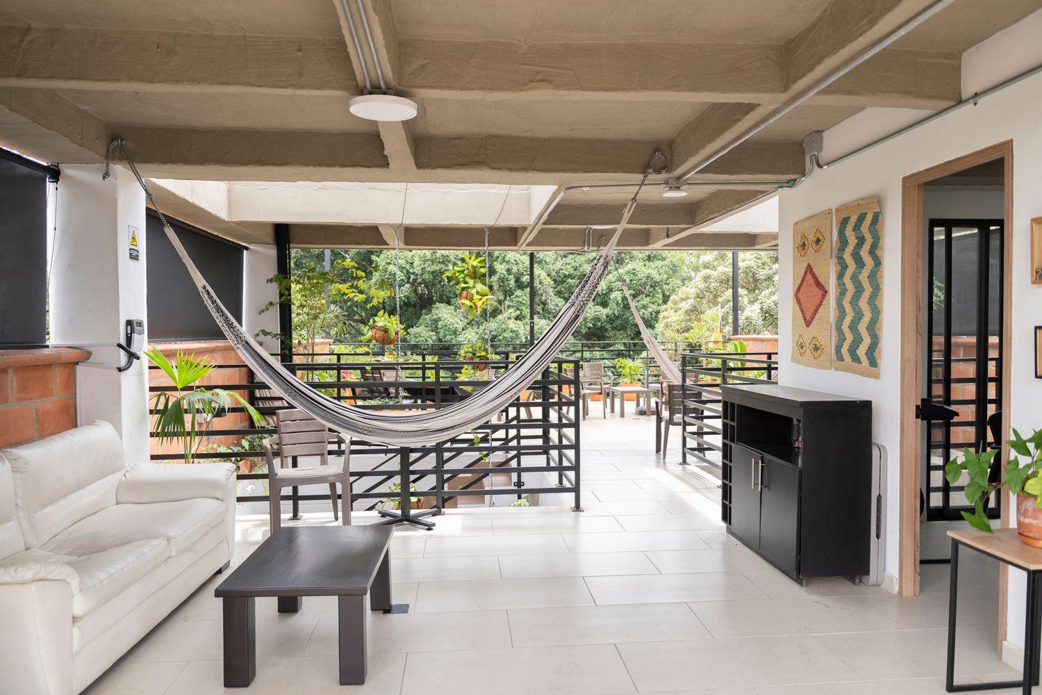 Rooftop terrace with hammock, lounge area, and lush park views