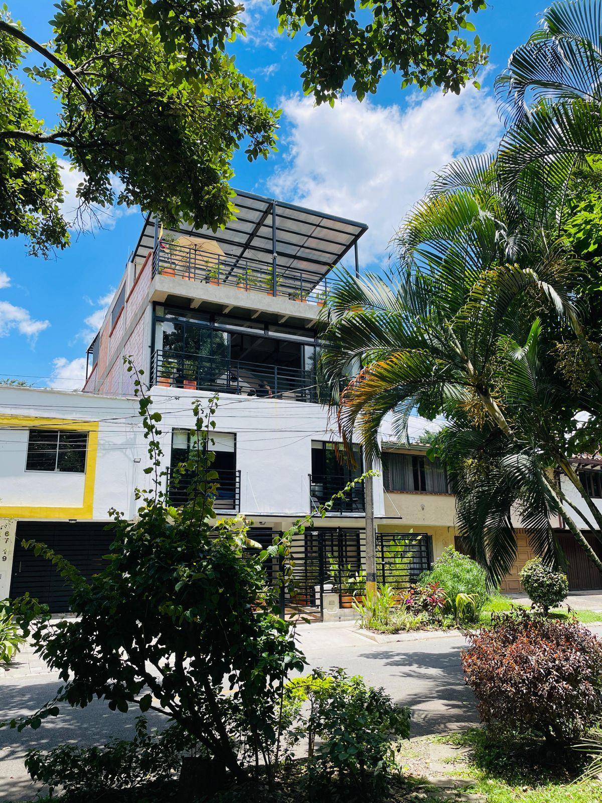 Exterior view of Caobo Home coliving building with rooftop terrace and tropical trees