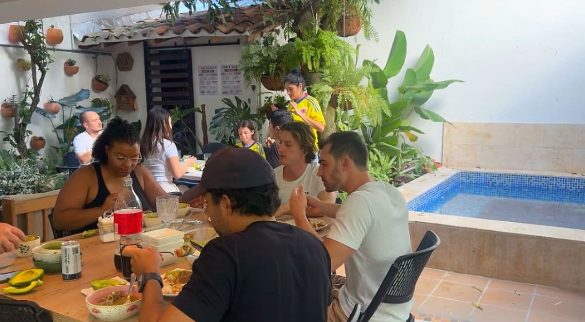 Group of residents having a meal together at a table next to the jacuzzi in the garden