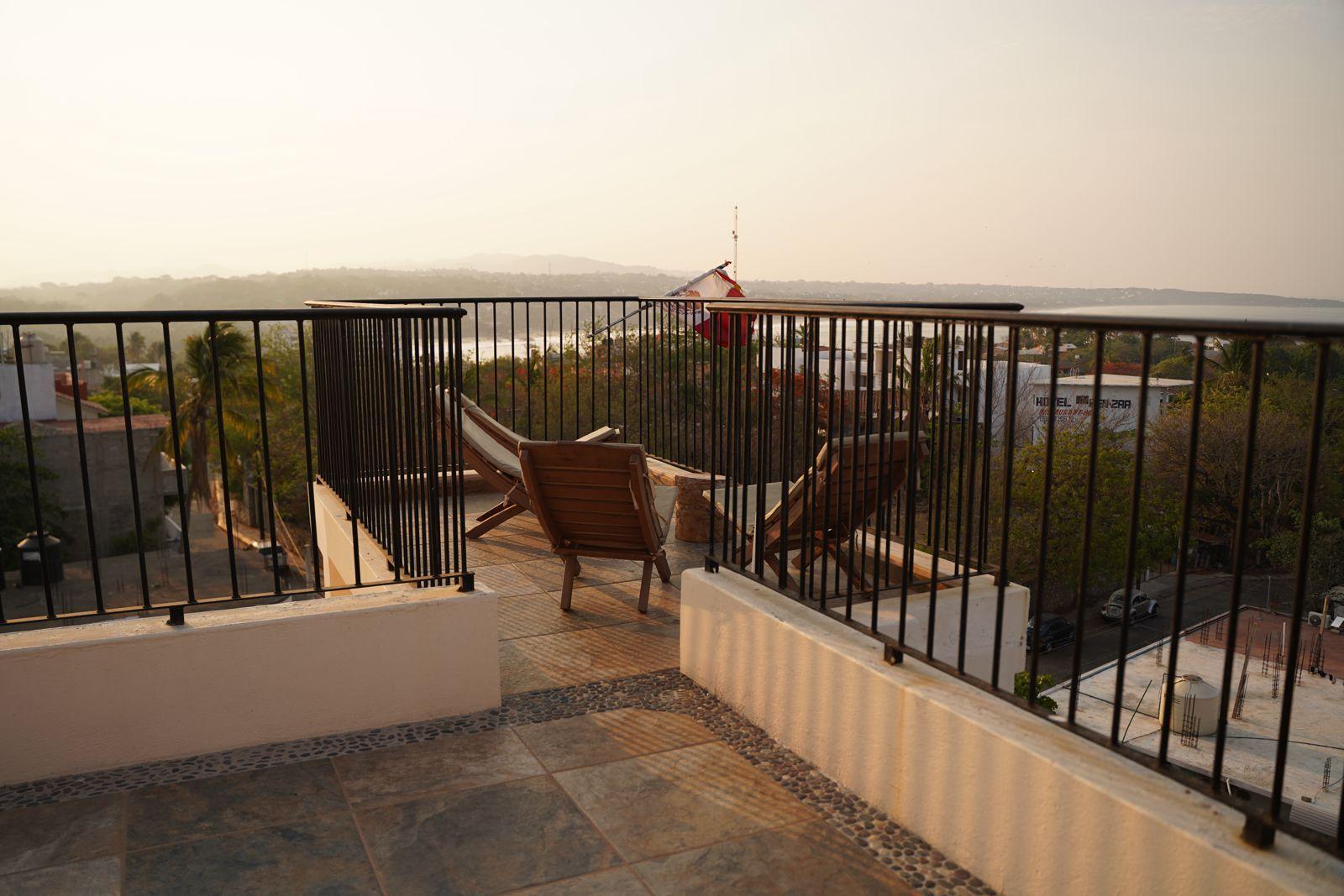 Rooftop terrace with lounge chairs and panoramic ocean and bay views