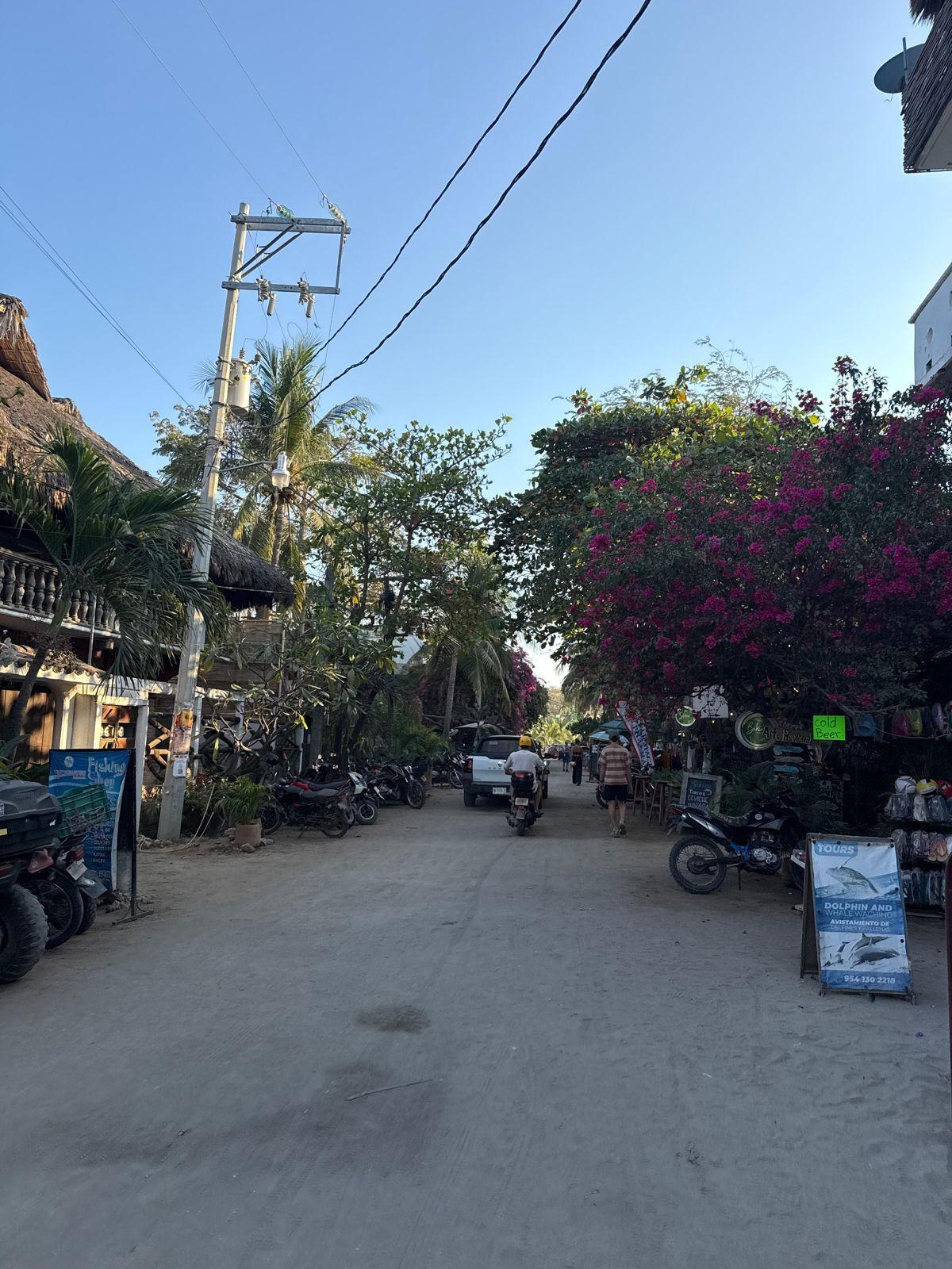 Street scene in La Punta, Puerto Escondido with shops and scooters