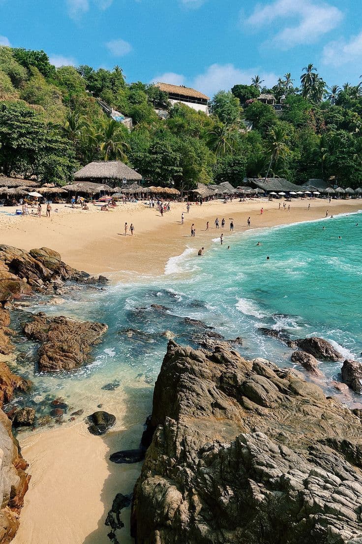 Beautiful beach near Puerto Escondido with turquoise water and palm-thatched umbrellas