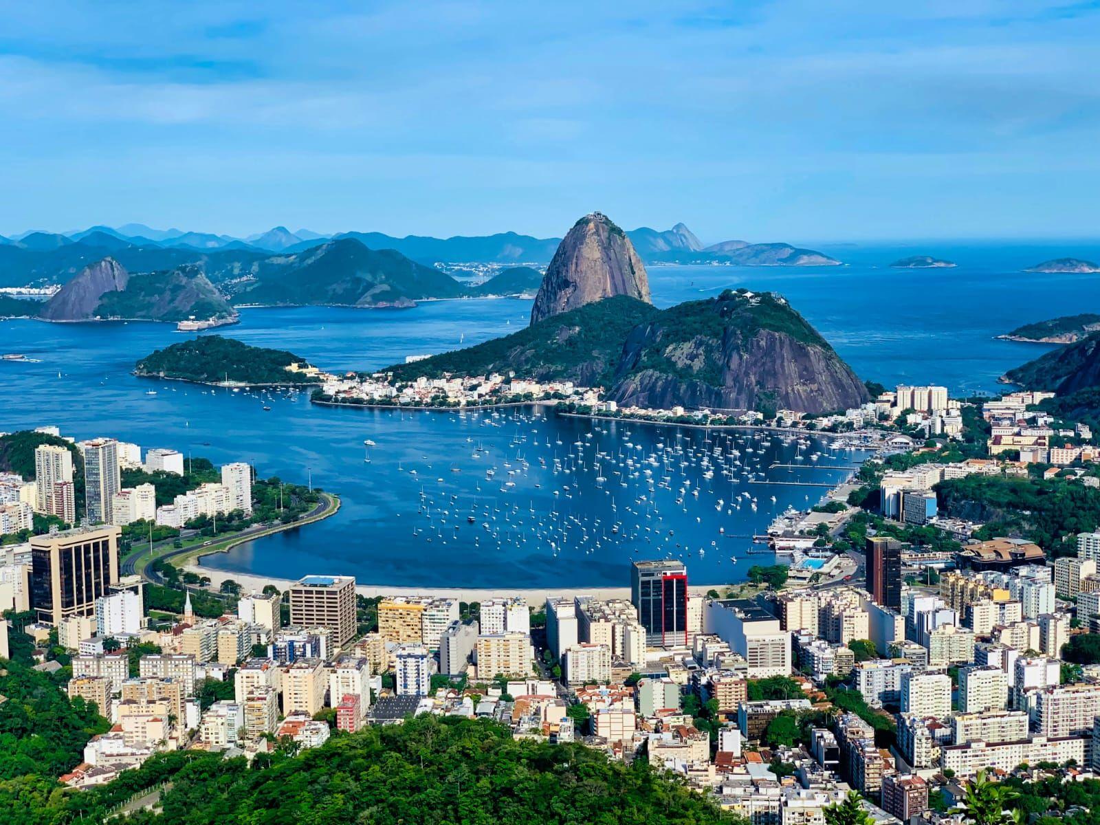 Iconic aerial view of Rio de Janeiro showing Sugarloaf Mountain (Pão de Açúcar), Guanabara Bay, and the city skyline