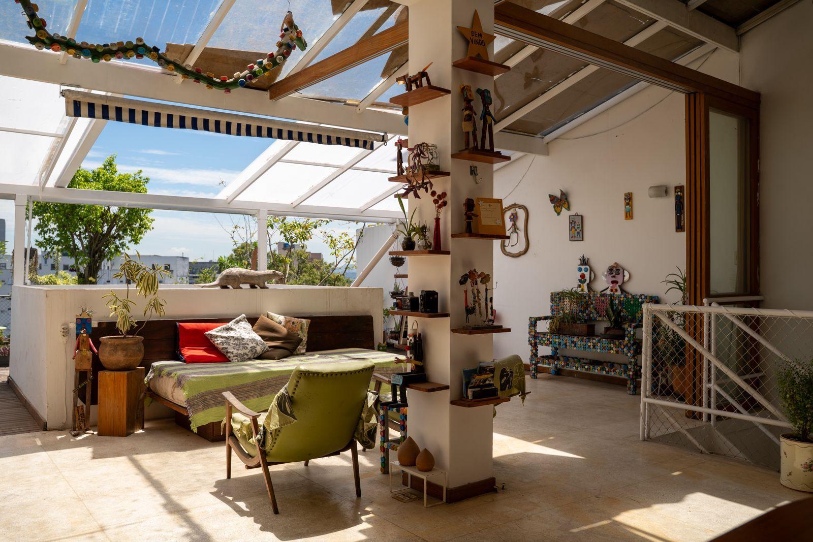 Rooftop terrace featuring eclectic art pieces, sculptures, a sofa, and glass roof panels with city views
