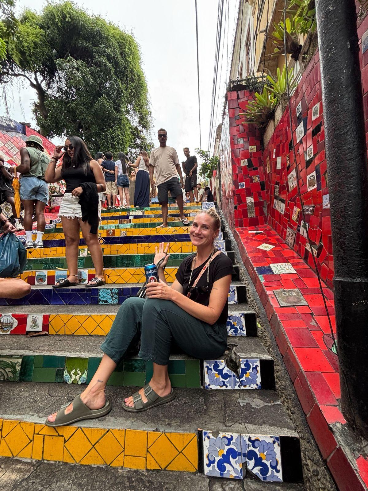 A guest sitting on the famous colorful tiled Escadaria Selarón steps in Santa Teresa, Rio de Janeiro