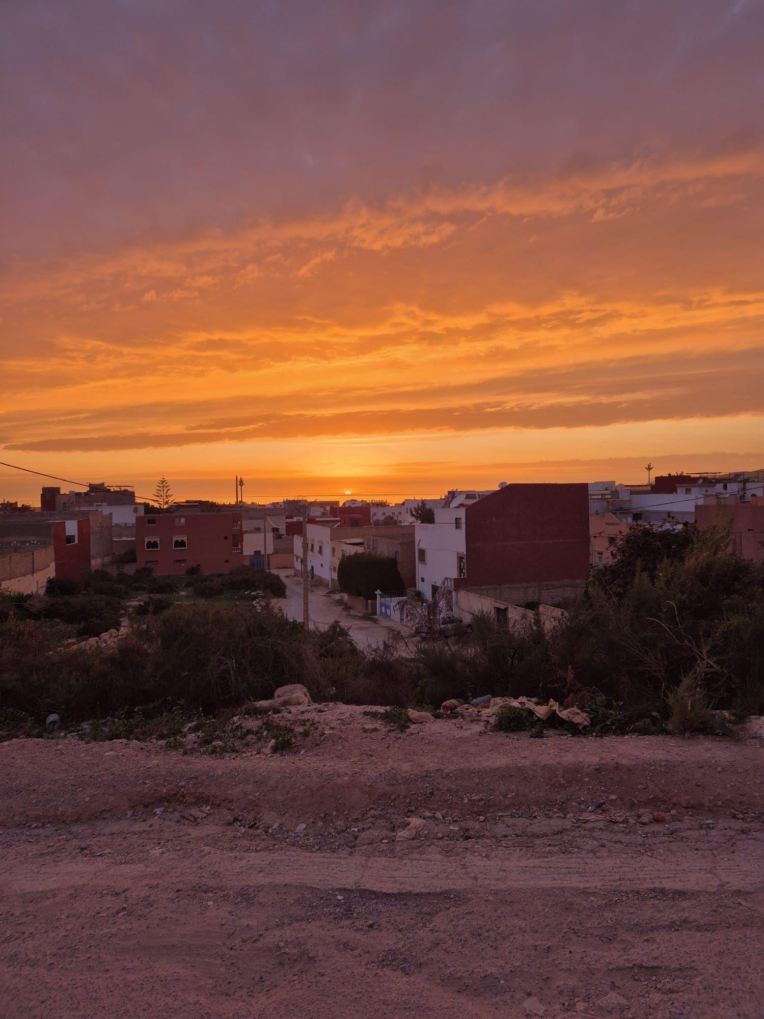 Panoramic view of Tamraght village at sunset with dramatic orange sky