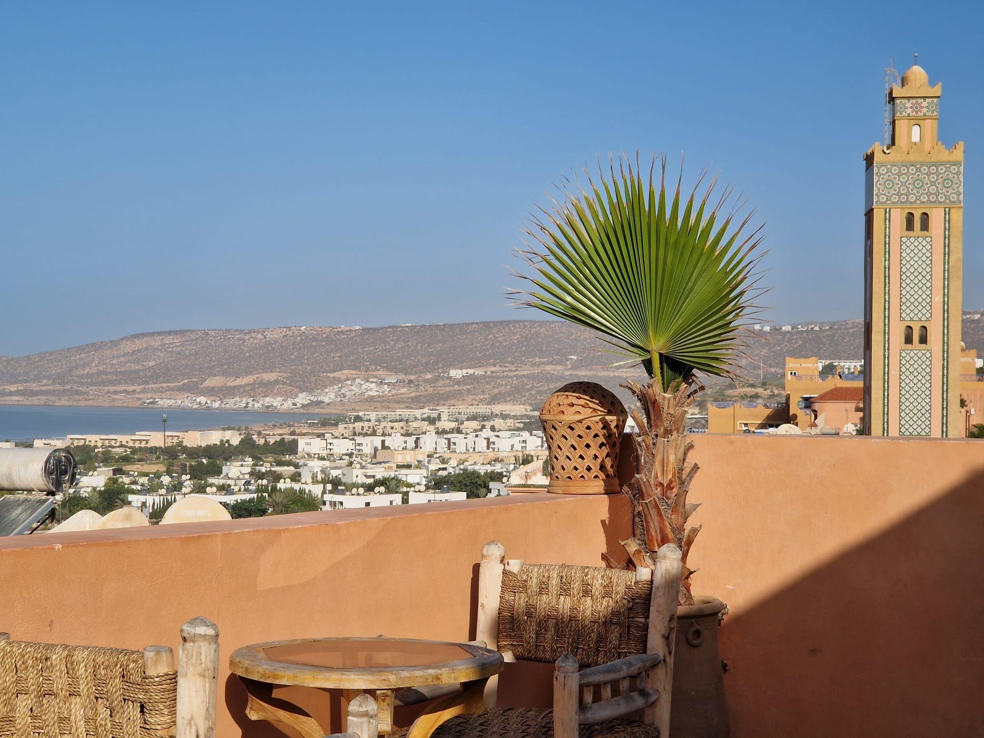 Rooftop terrace view with mosque minaret and bay visible in the background