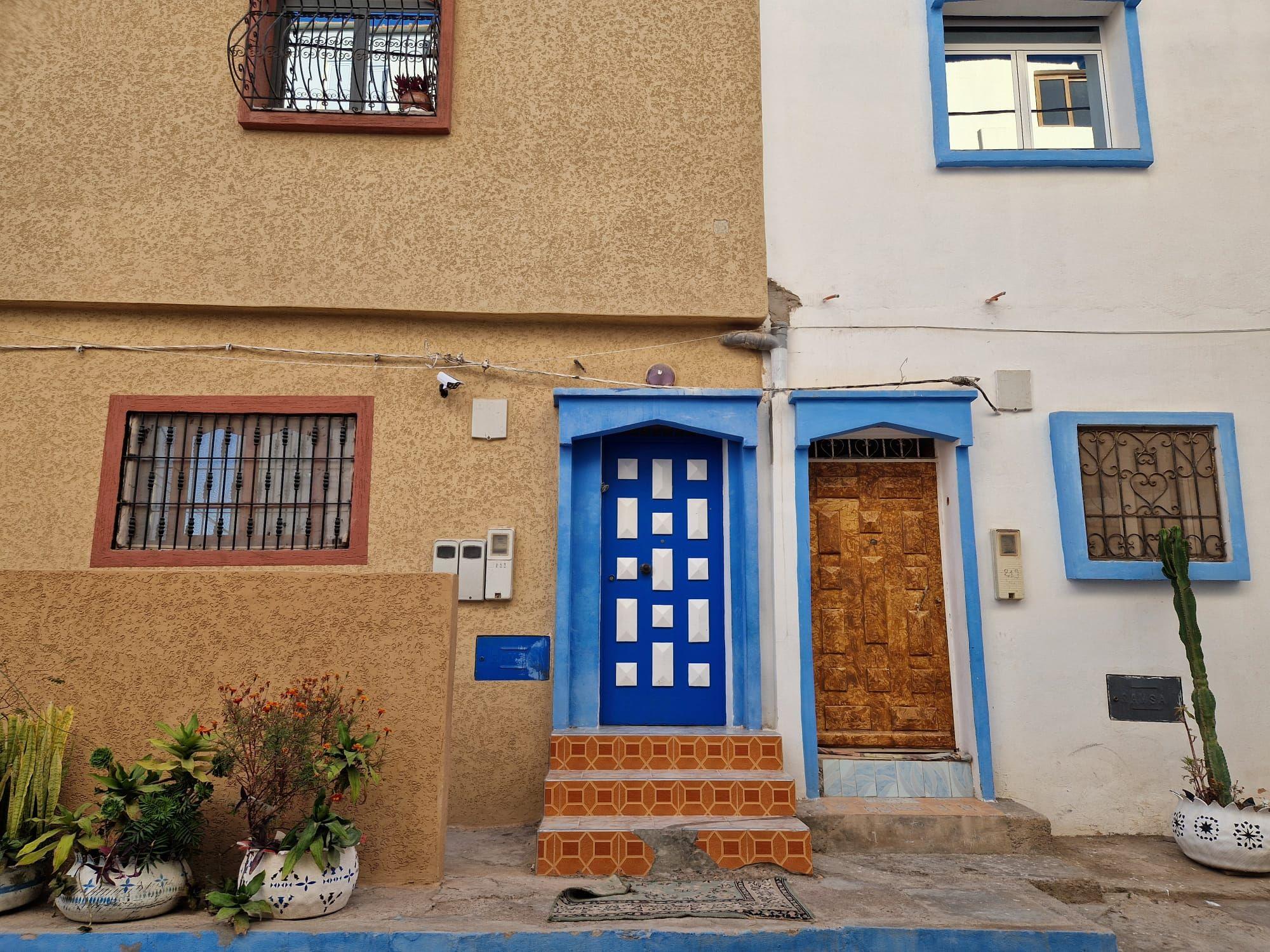 Street-level exterior view of Abdel Sin with blue-painted doors and traditional Moroccan architecture