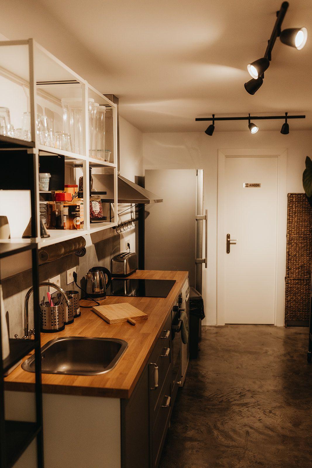 Fully equipped shared kitchen at Tarifa Hub with open shelving, sink, and appliances