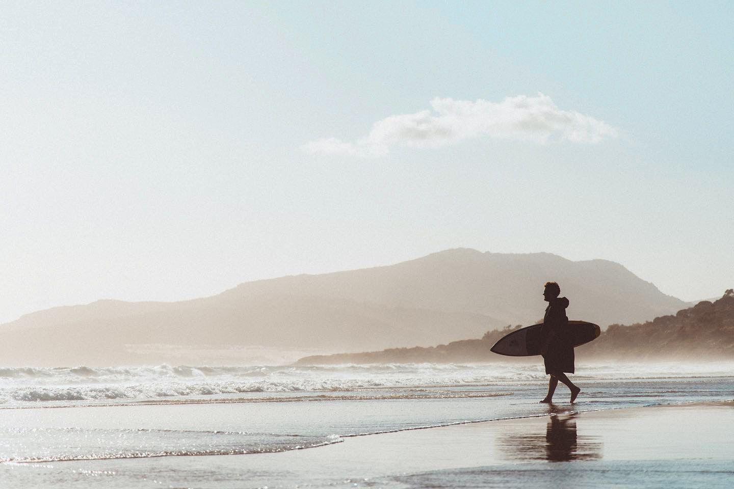 Silhouette of a surfer carrying a surfboard along the beach at Tarifa