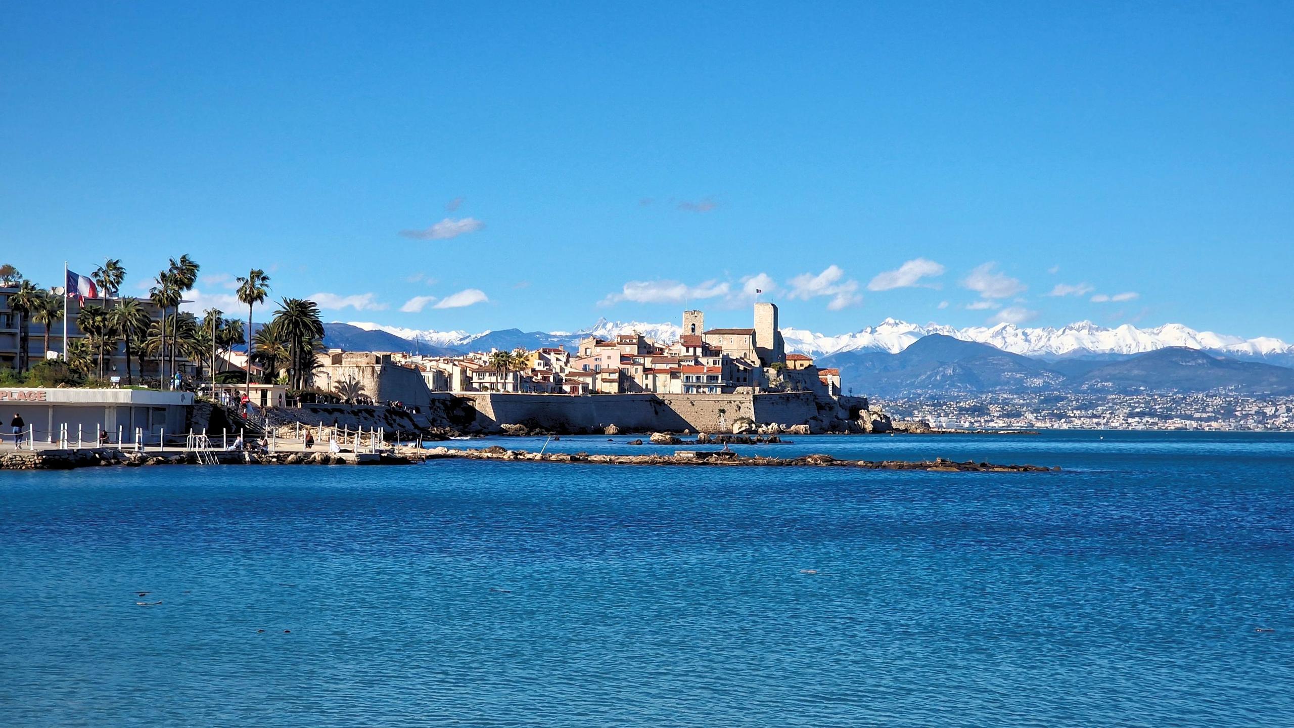 Panoramic view of Antibes old town with snow-capped Alps and blue Mediterranean sea
