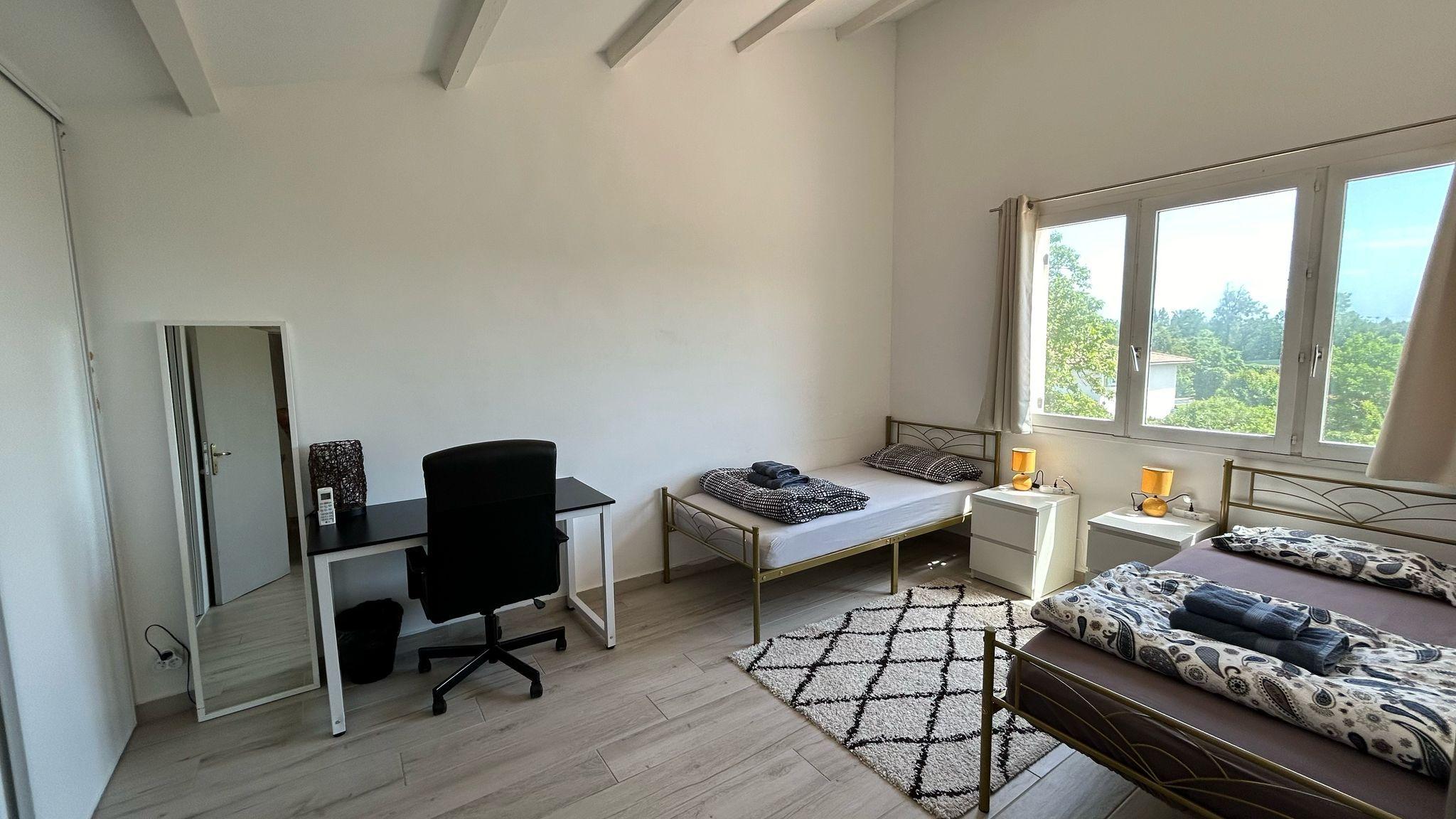 Room Nice showing the workspace area with desk, office chair, and windows with garden views